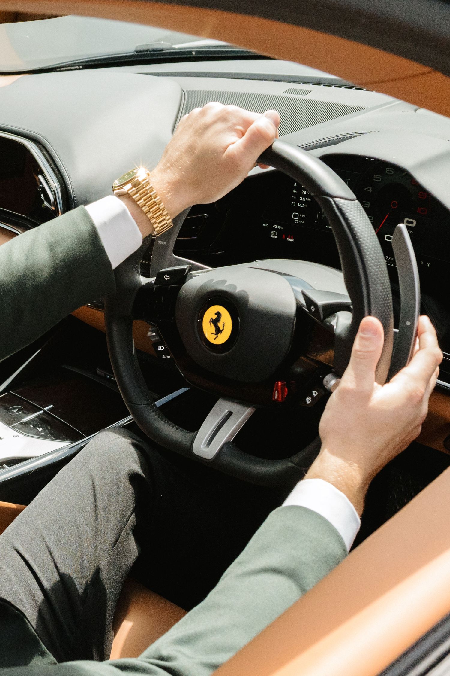 Close-up sequence showing hands gripping and turning a Ferrari steering wheel while driving.