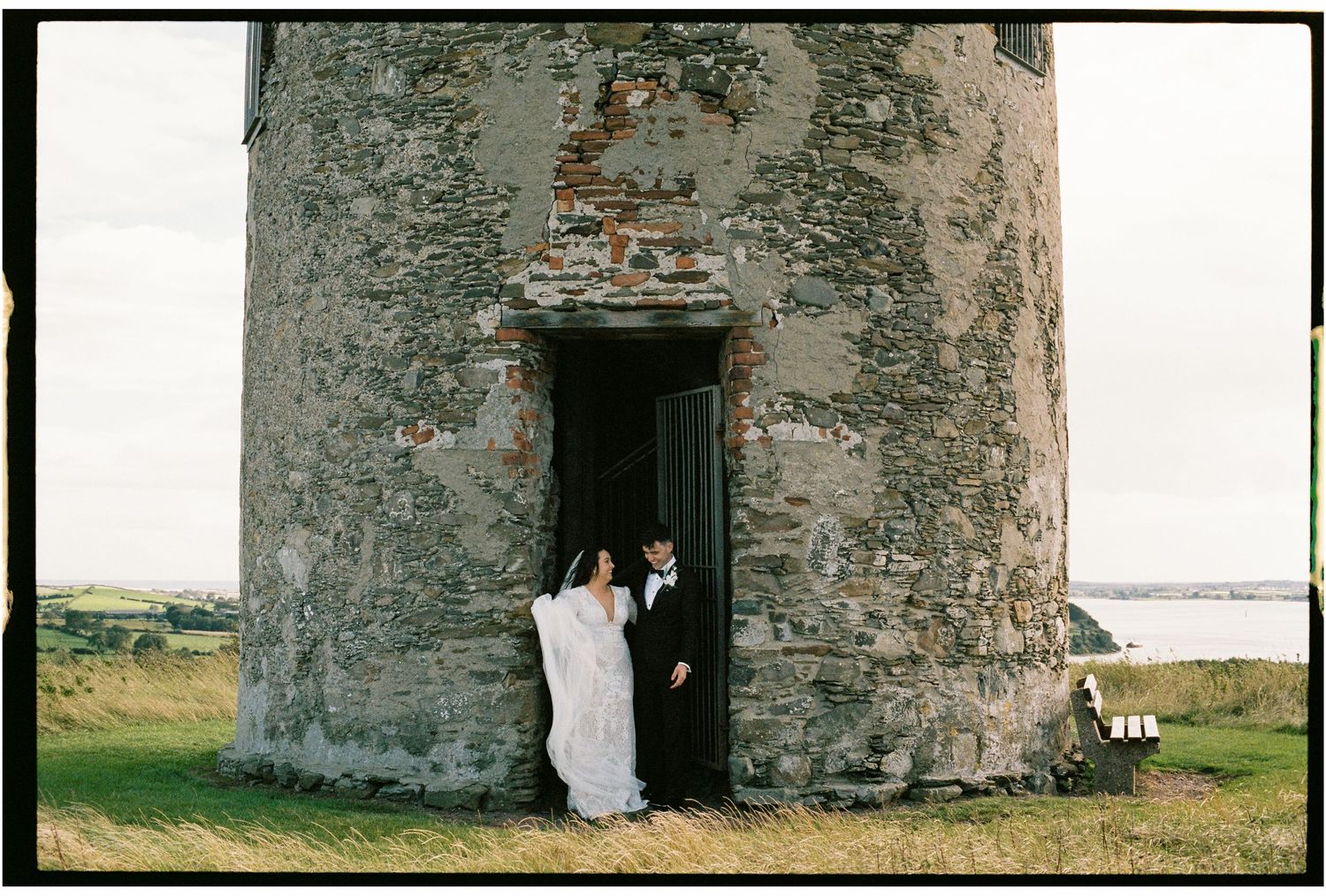 Stone tower or fortress with doorway entrance against cloudy sky.