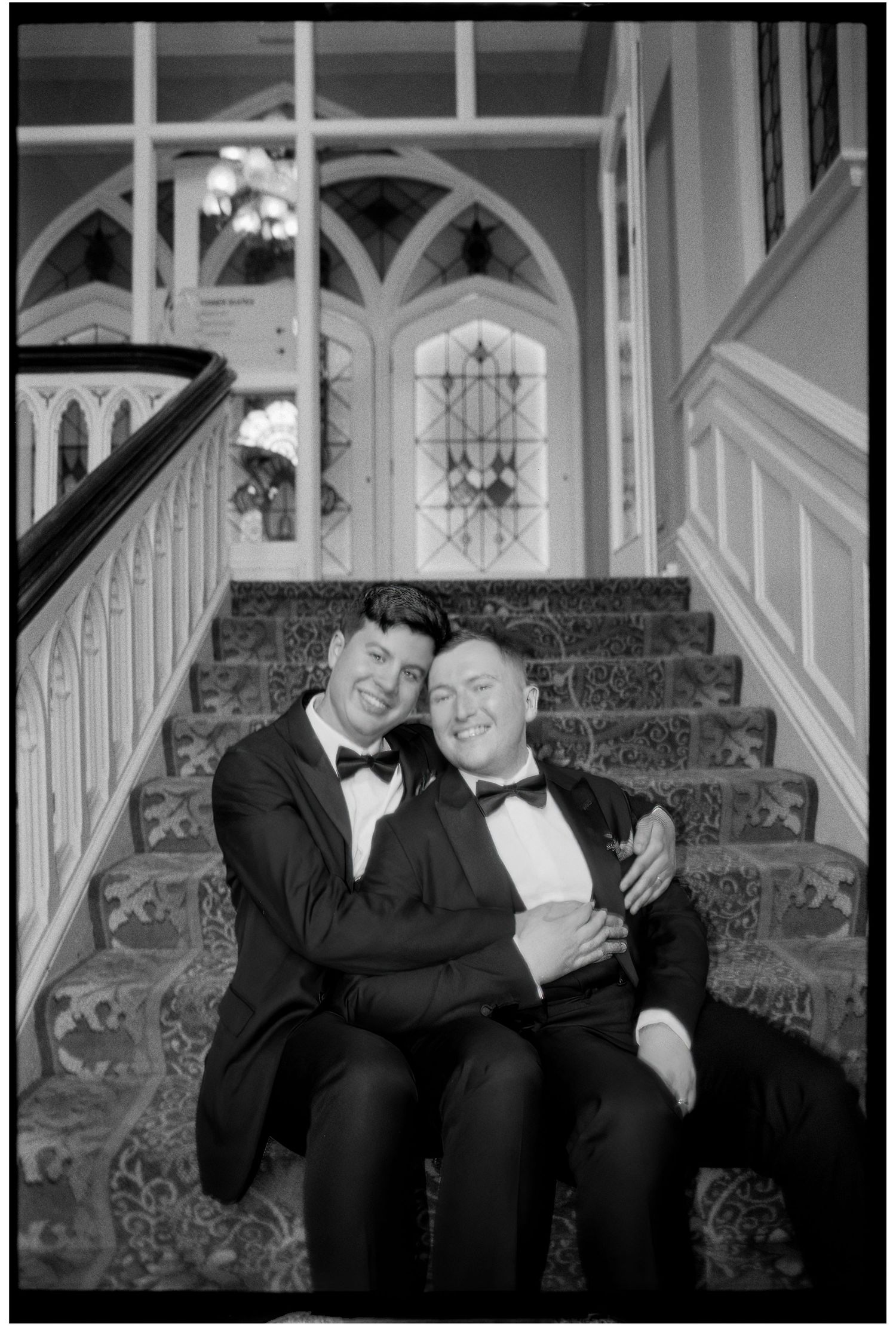 Two people in tuxedos sitting together on ornate stairs in black and white photos.