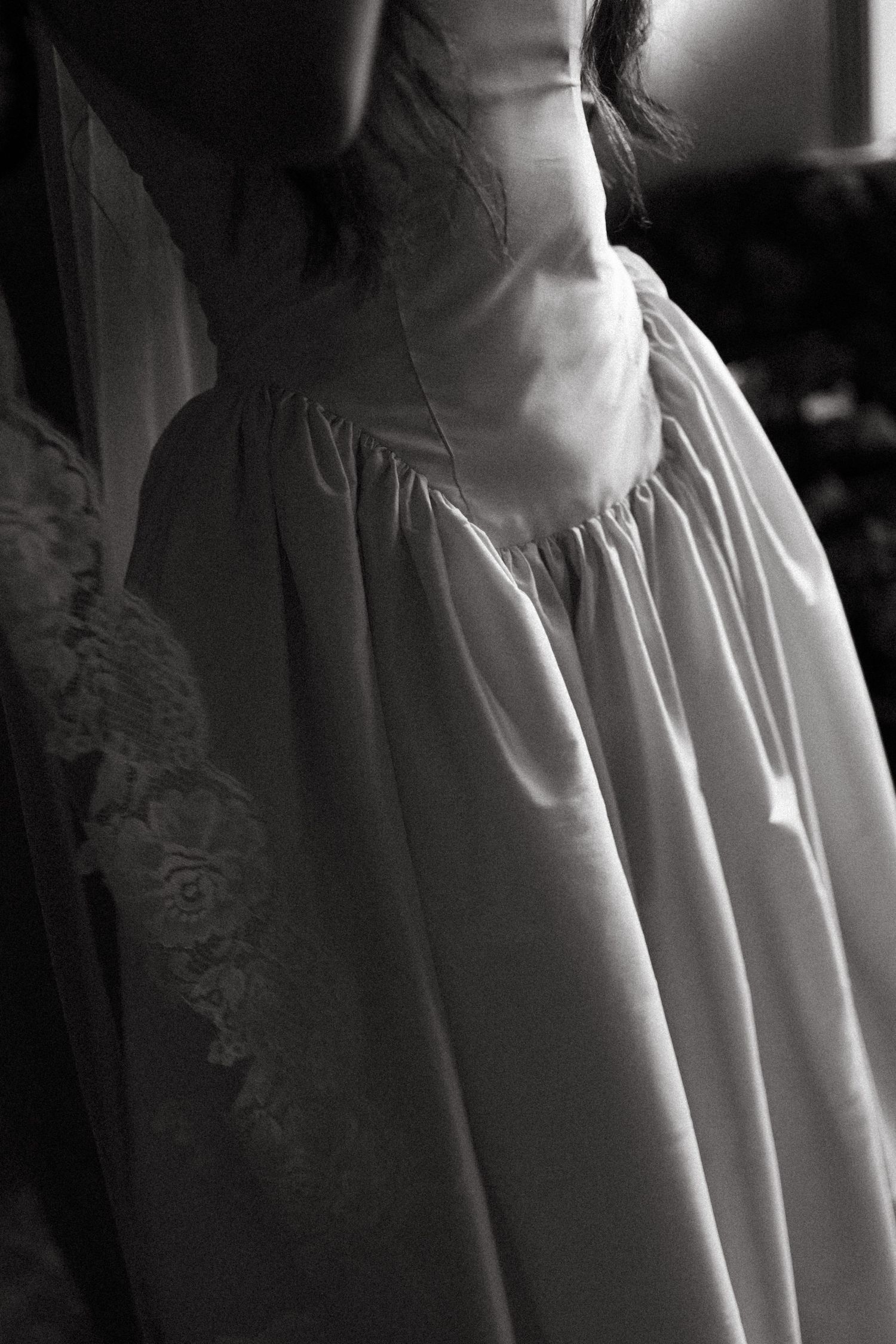 Close-up detail of white gathered fabric with delicate pleats and soft shadows creating an elegant textural pattern.