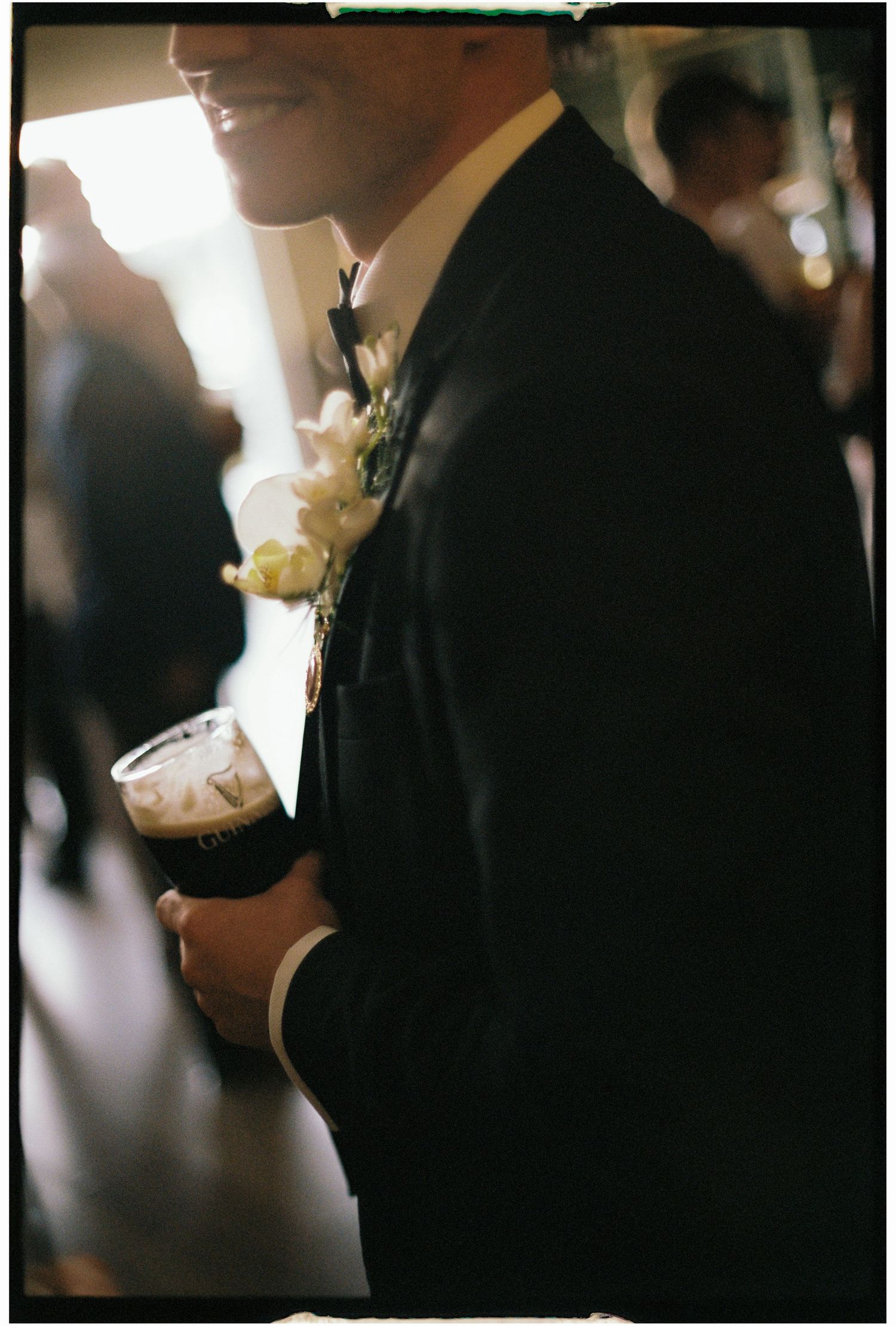 Silhouetted figures in formal attire at an indoor event.