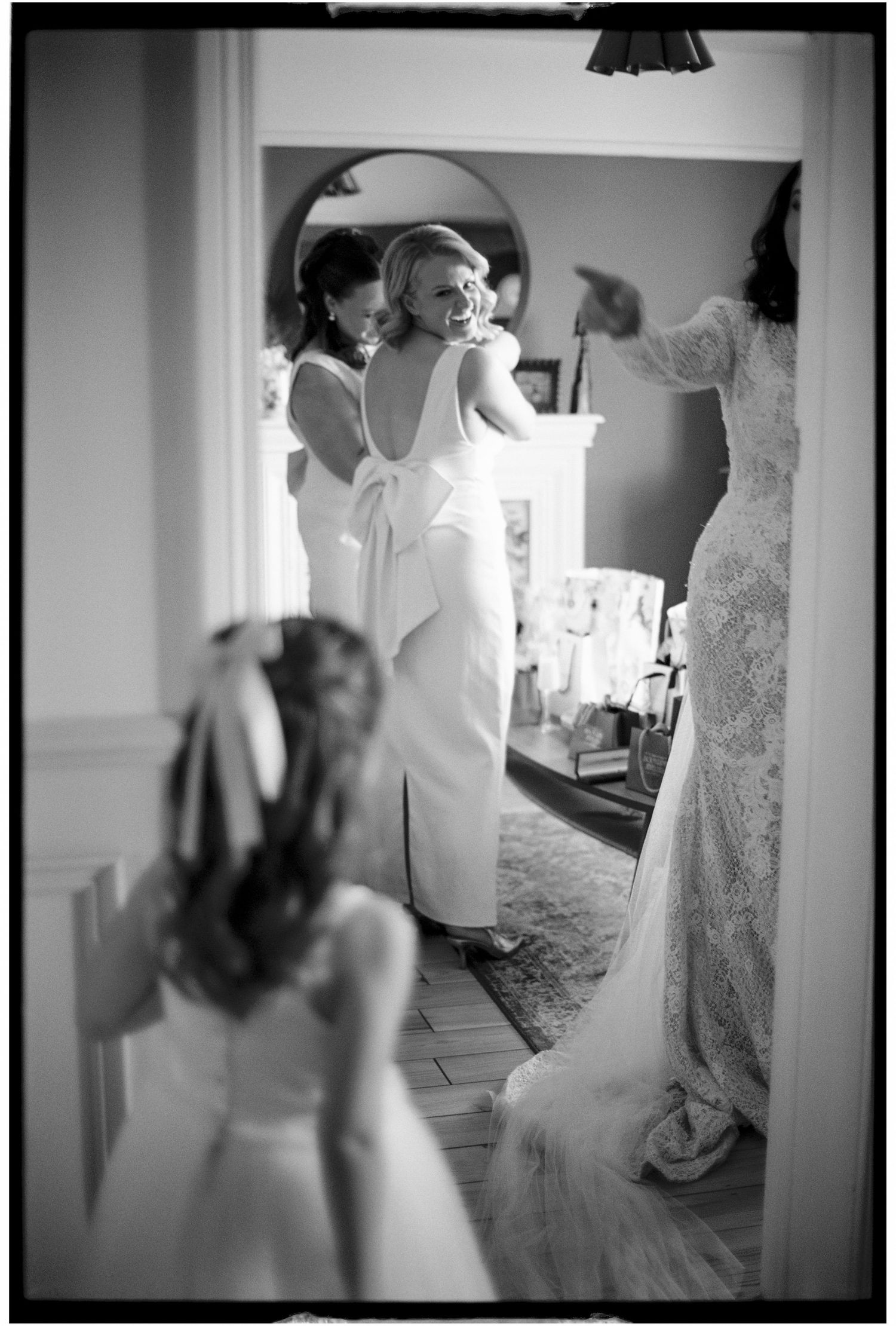 Black and white photo of wedding preparations showing a dress and mirror reflection.