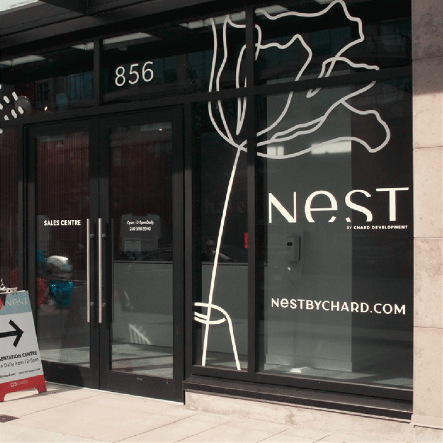Nest by Chard Development sales centre storefront at with elegant floral window graphics.