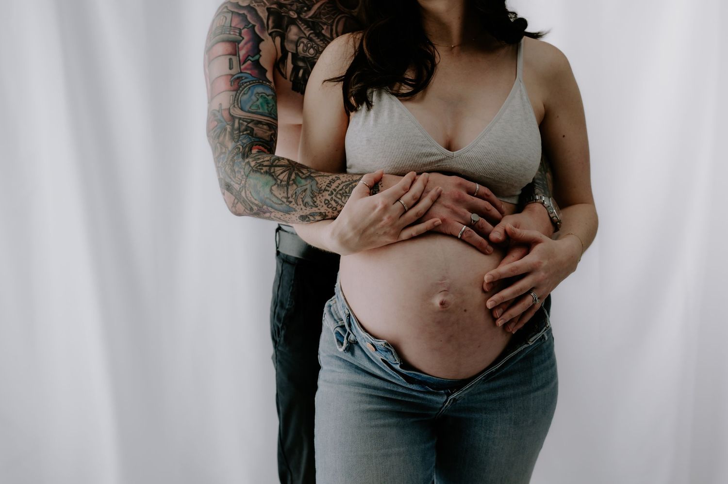 Intimate maternity photos of pregnant belly and gentle embraces, studio