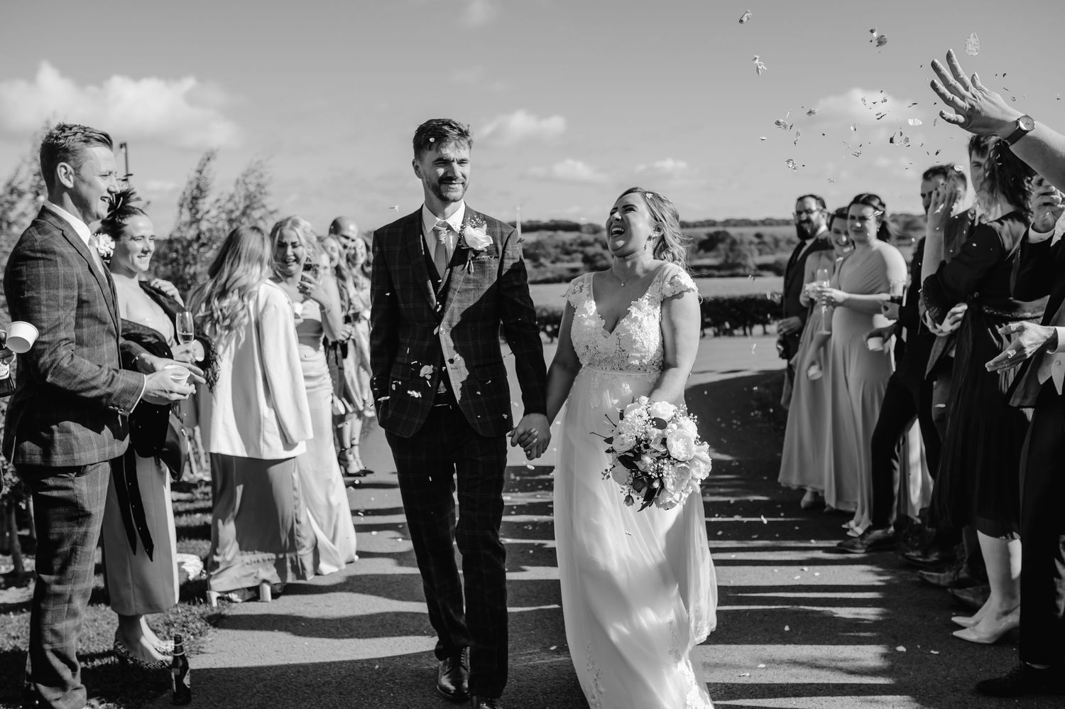 Black and white photos show tender moments with guests during an outdoor wedding celebration.