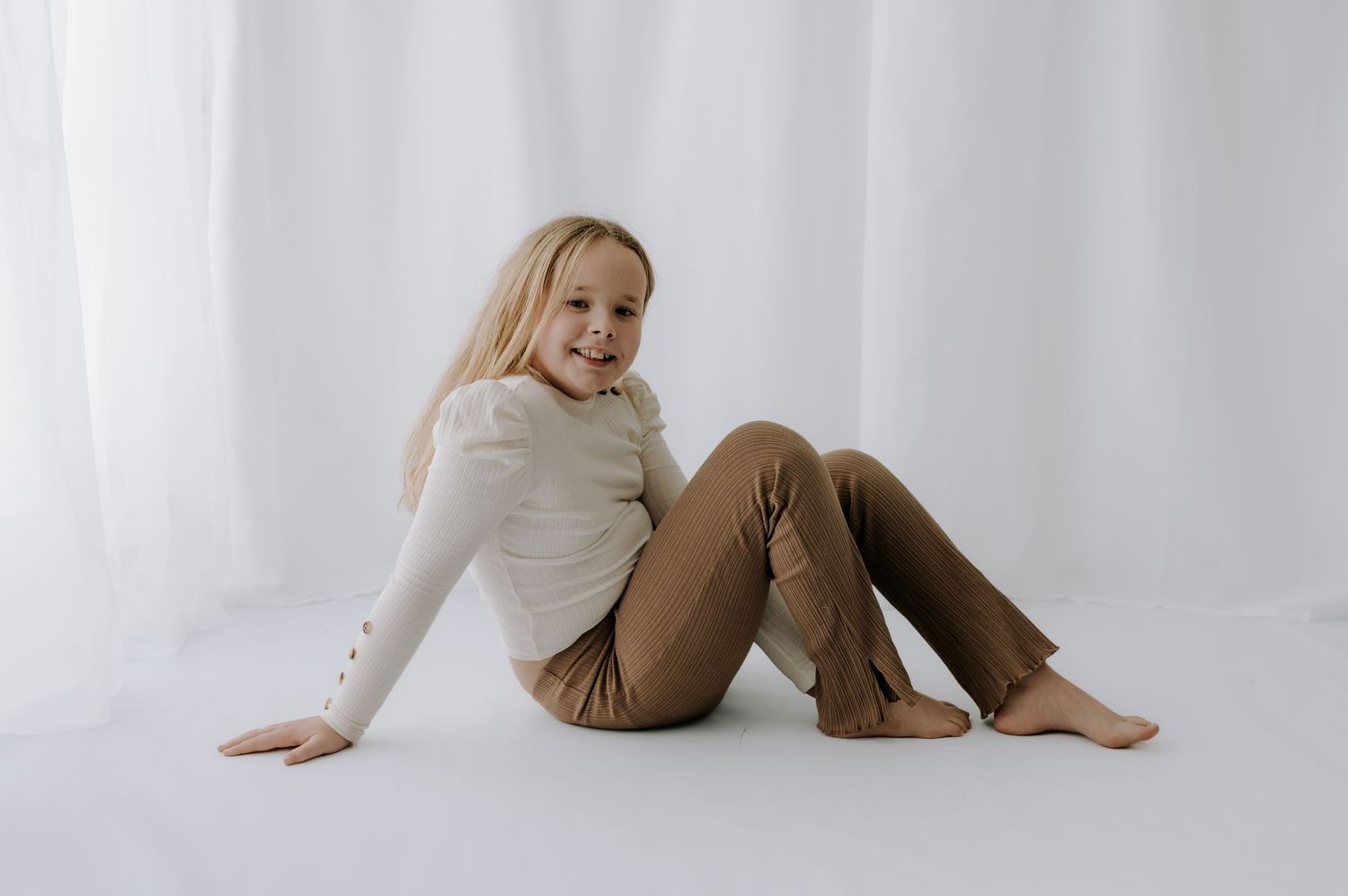 Person sitting on floor relaxed, white curtain backdrop, studio, Melton Mowbray.
