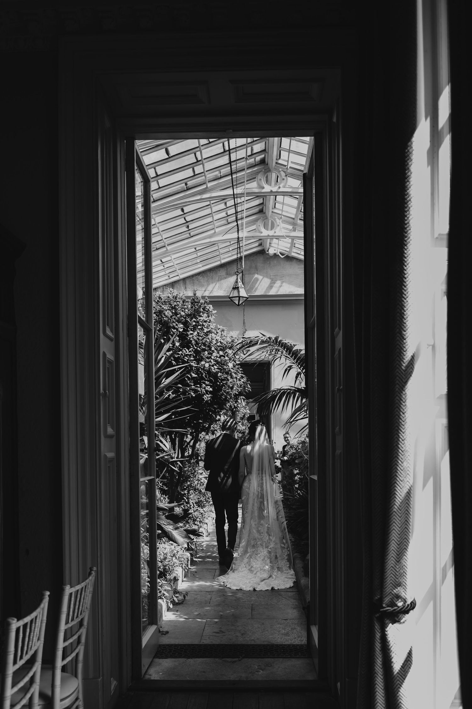 A black and white silhouette sequence shows a couple in a sunlit corridor framed by architectural windows and doorways.