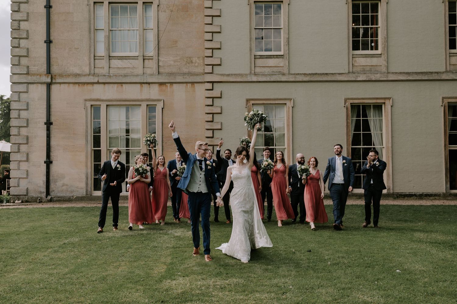 Wedding party group portraits taken in sequence on a grand estate lawn surrounded by historic architecture.
