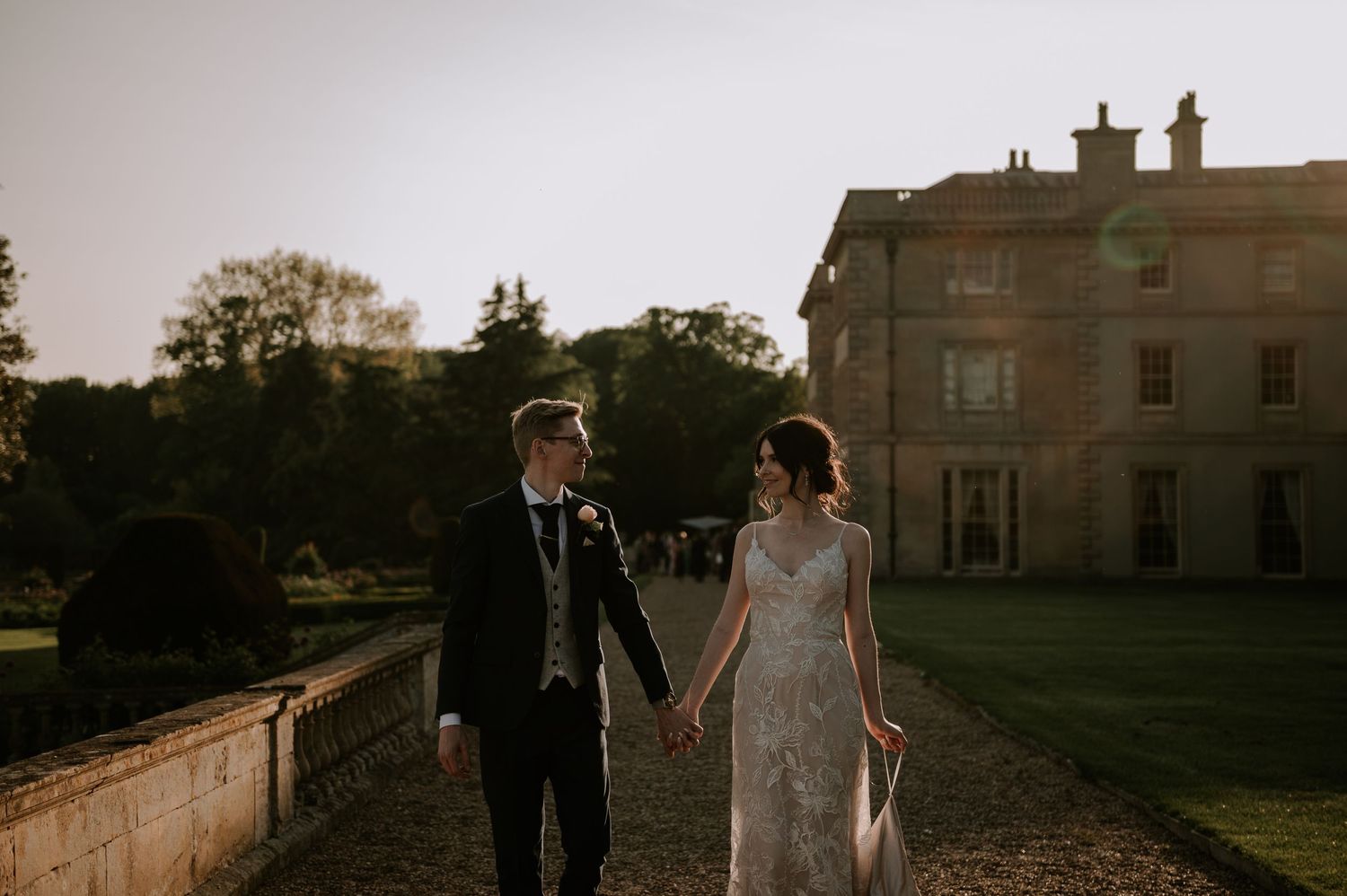 A collage of wedding photos showing a couple walking together at sunset near a historic building with a stone pathway.