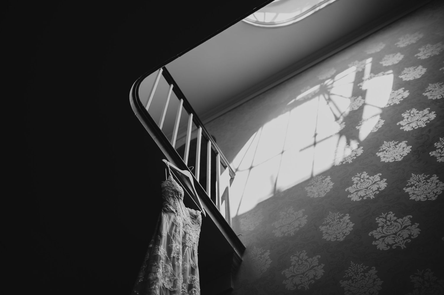 A Christmas holiday scene with snowflake ornaments hanging in front of a bright window with sunlight streaming in.