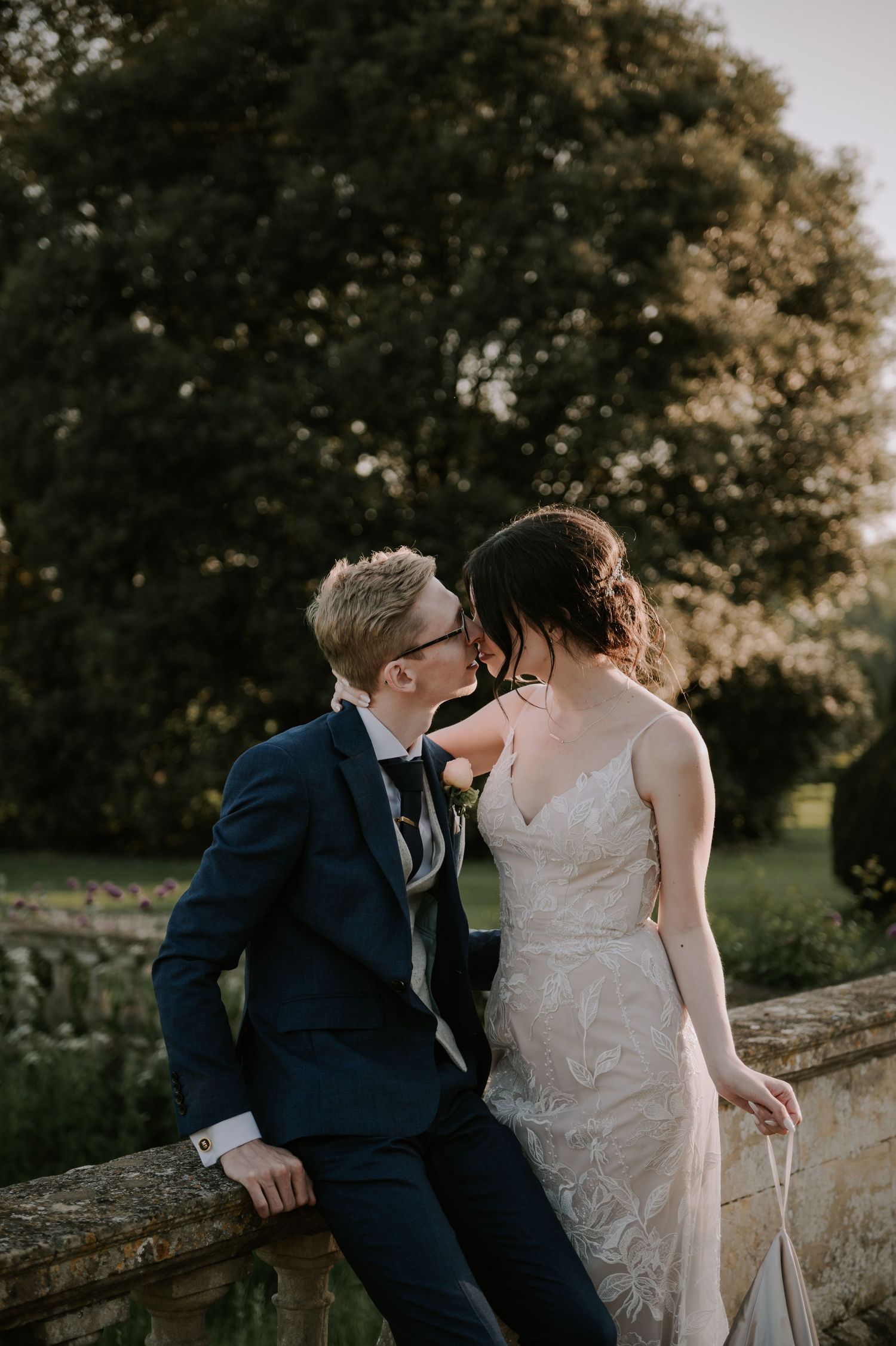 Romantic newlywed couple share an intimate moment together outdoors at sunset.