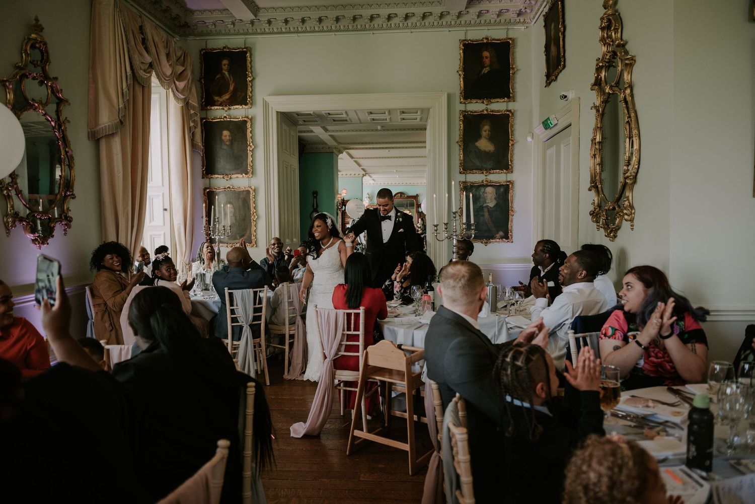 Couple entering dinner holding hands in Prestwold Hall wedding venue, Loughborough wedding