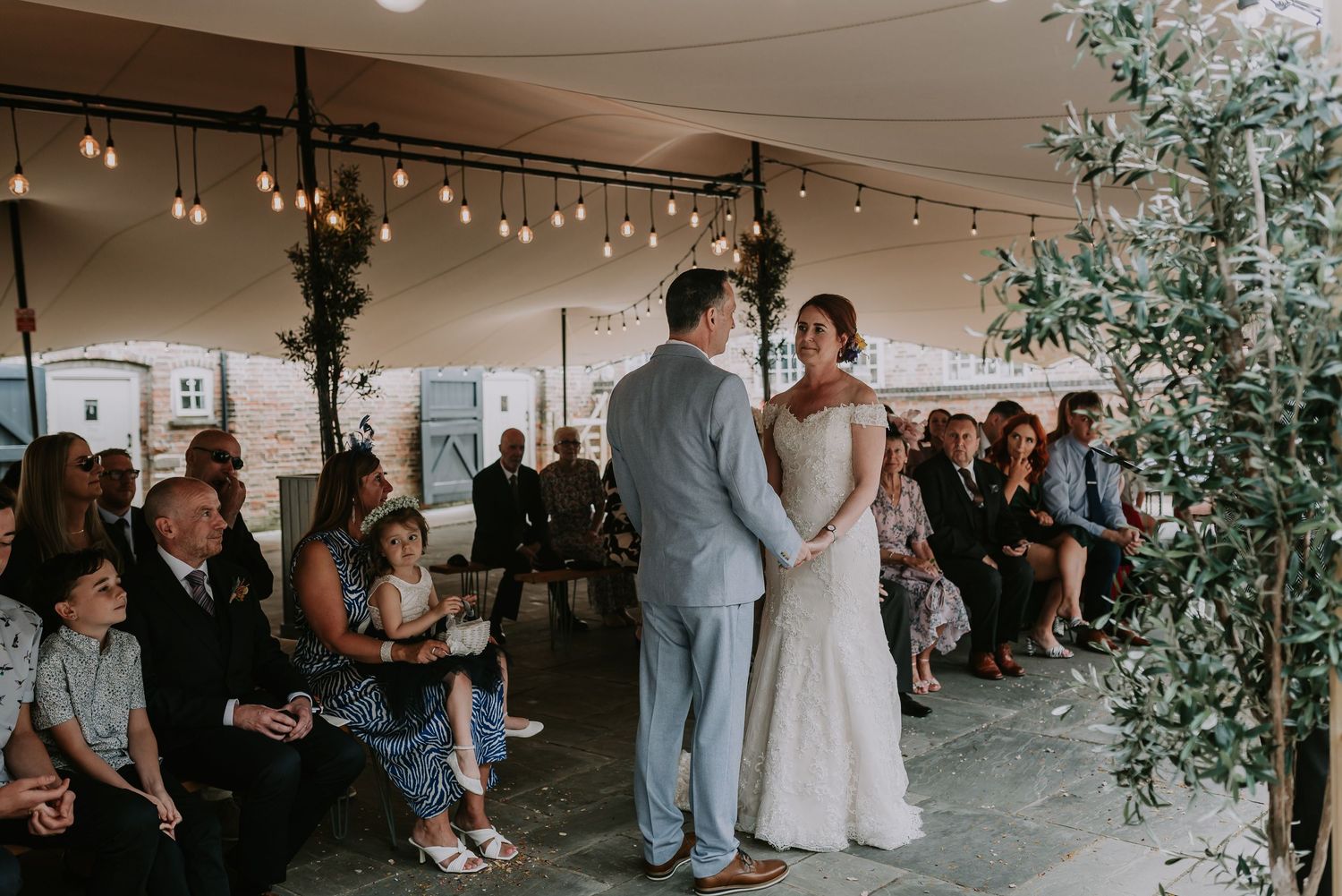Wedding guests celebrate at a romantic reception with minimalist decor and eucalyptus greenery arrangements.