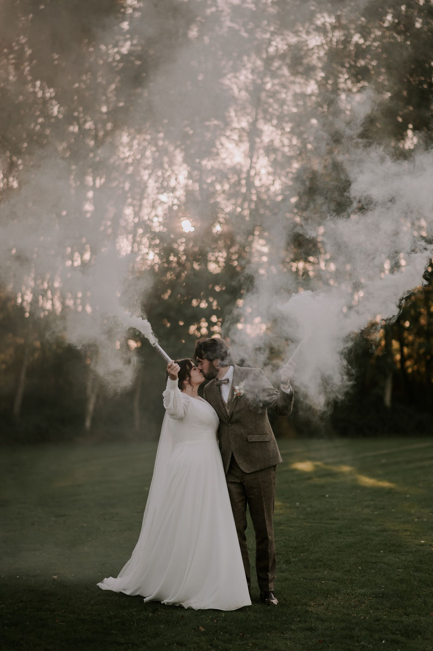 Couple with white smoke bombs, sunset through trees, romantic golden light, Melton Mowbray wedding.