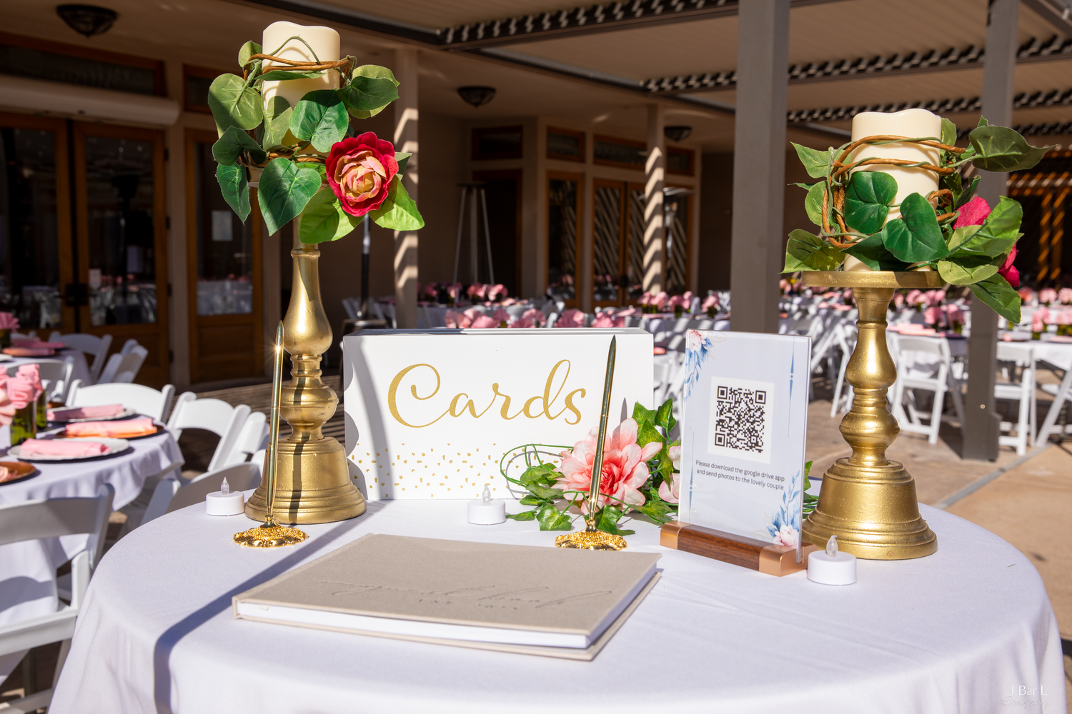 Wedding cards table with gold candle holders, floral arrangements, and QR code sign.