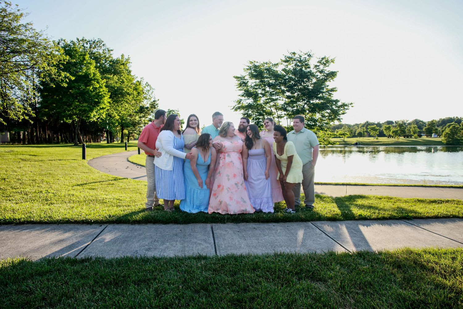 Extended family of mom, dad, siblings and spouses in spring outfits at the Coxhall Gardens Park in Carmel, IN.