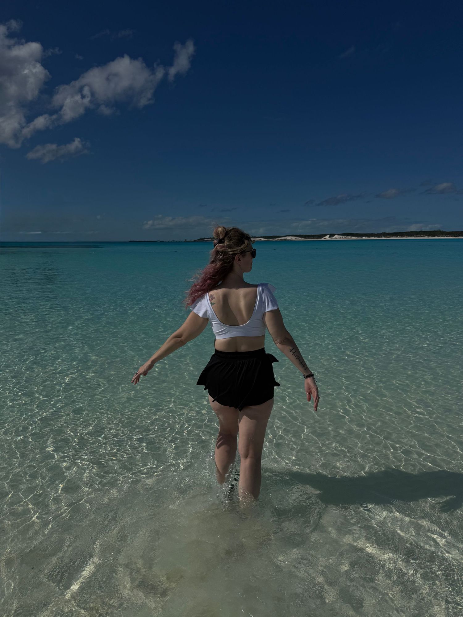 Woman in ocean water, walking and enjoying the Bahamas on Half Moon Cay Island.