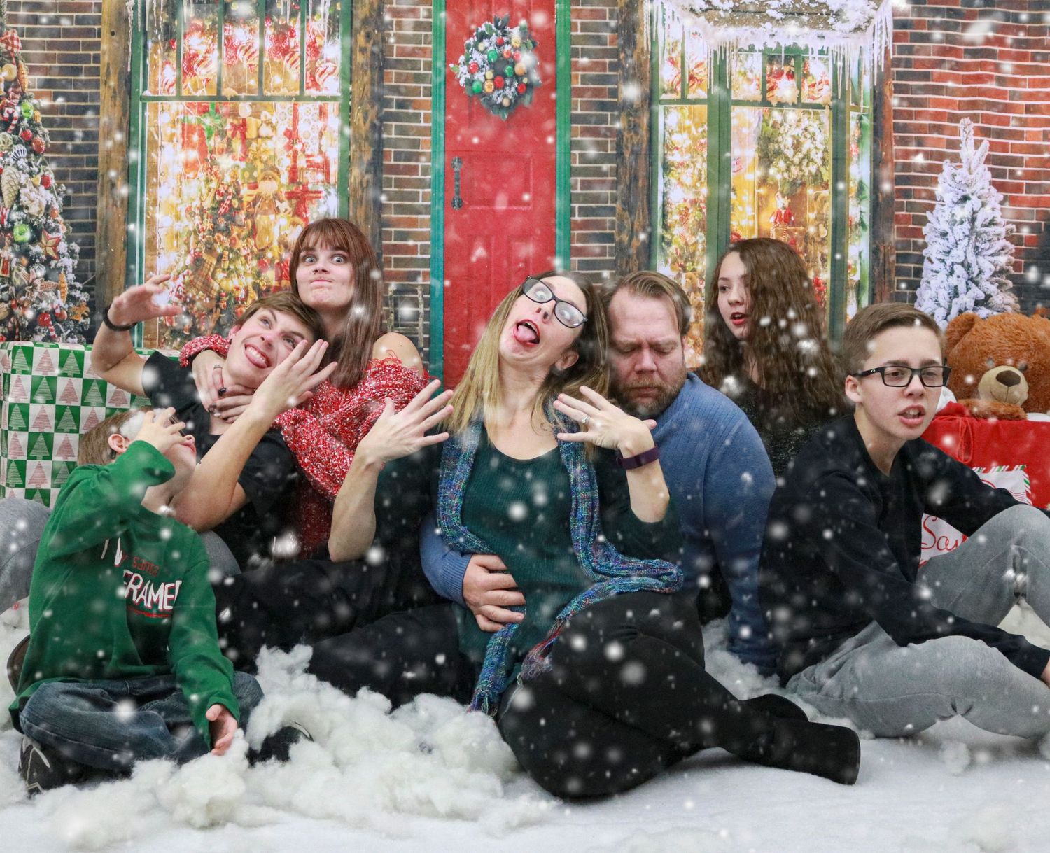 Family of mom, dad, and siblings making goofy faces during a Christmas photoshoot in Indianapolis, IN.