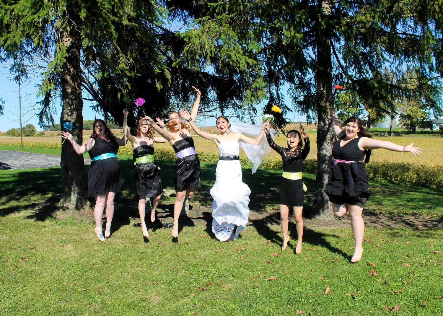 Bridesmaids jumping for joy after wedding ceremony in Lewisville, IN.