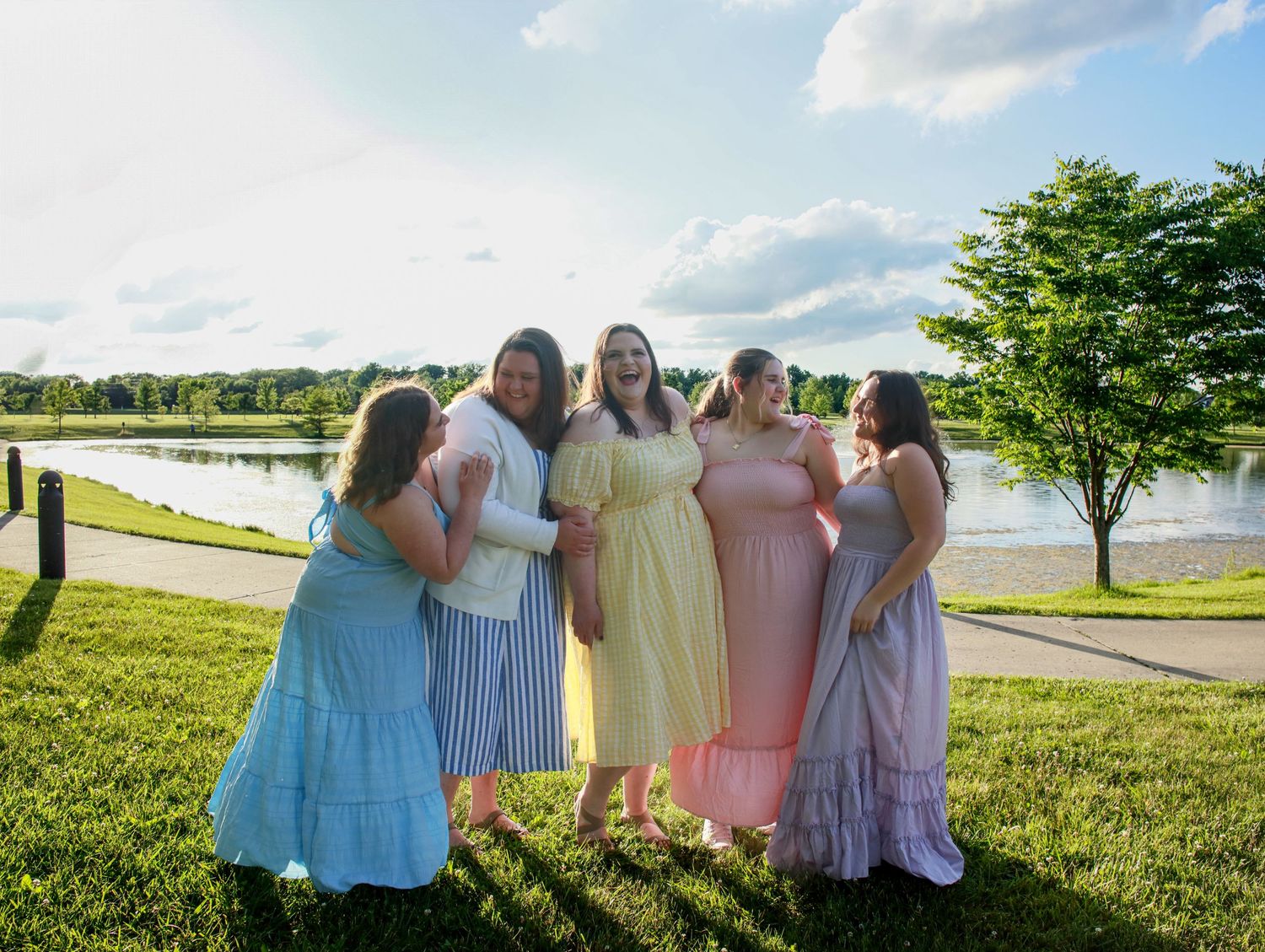 Sisters laughing and giggling together and embracing each other at Coxhall Gardens in Carmel, IN.