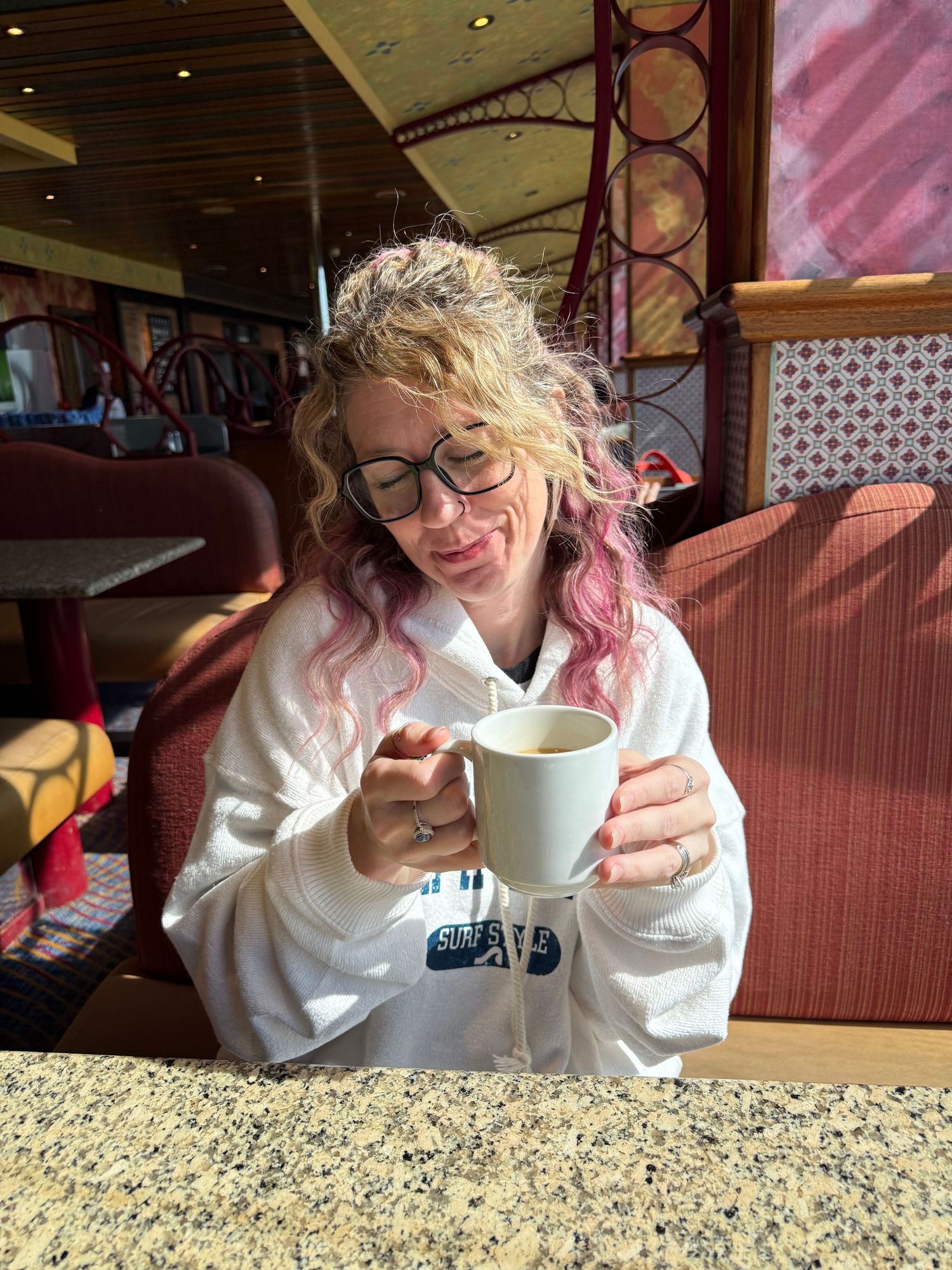 Woman drinking coffee and enjoying life on a cruise ship, traveling to Bahamas.
