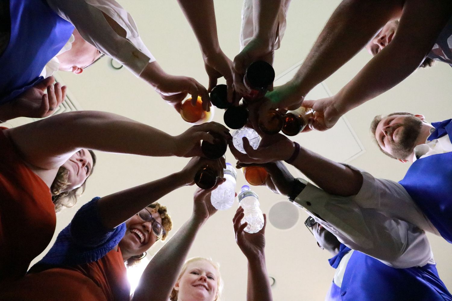 Bridal party clinking their glasses together for a cheers.