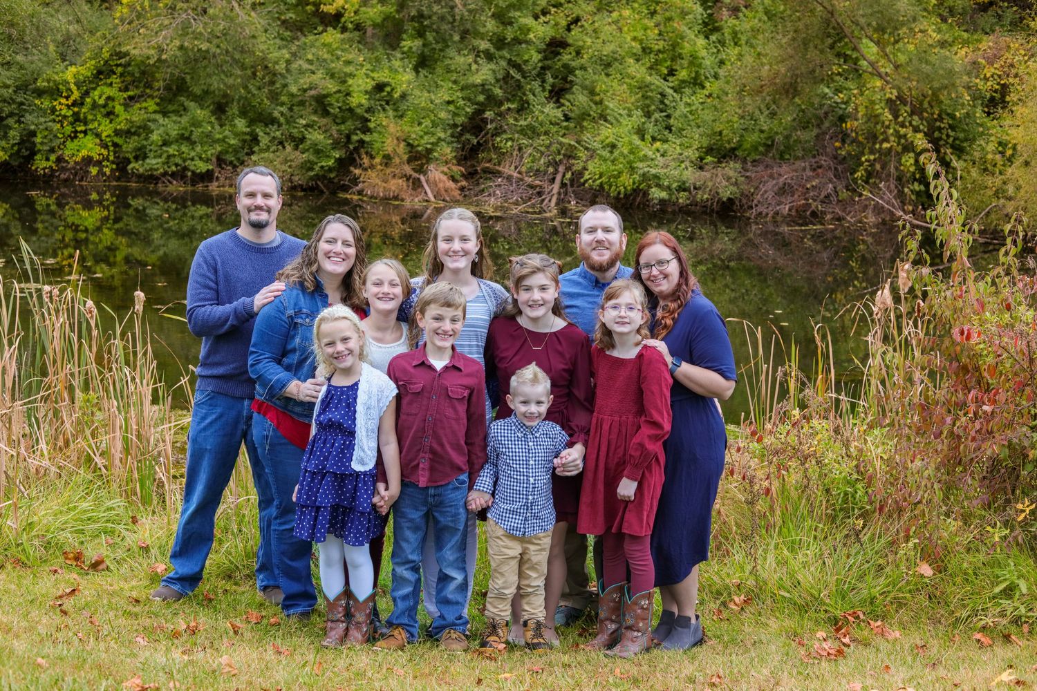 Extended family of two moms and dads with children at Fort Harrison State Park, standing together and holding hands.