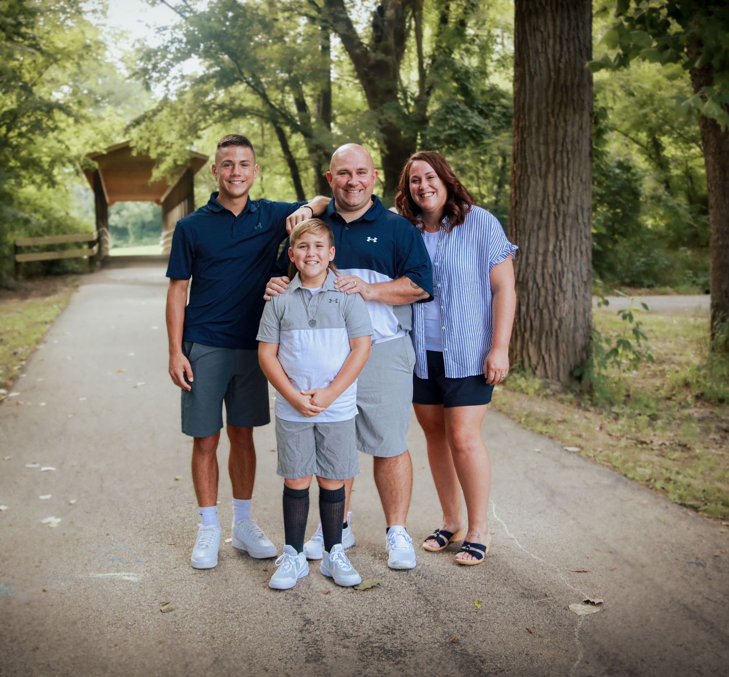 Family of mom, dad, and two sons standing together at Pioneer Park in Mooresville, IN.