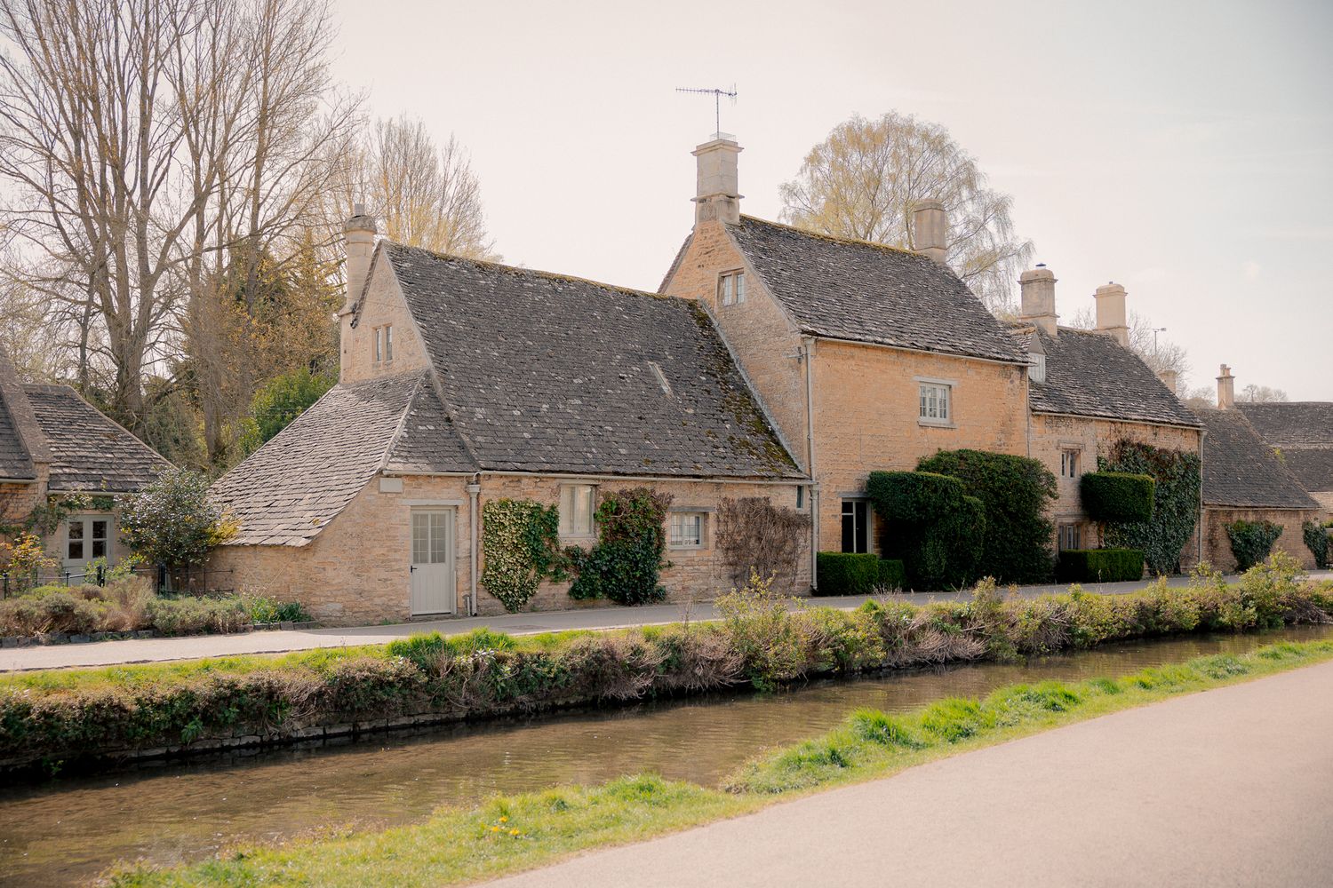 Charming Cotswold stone cottages beside a tranquil stream in an idyllic English village setting  in Lower Slaughter, Cotswolds, UK.