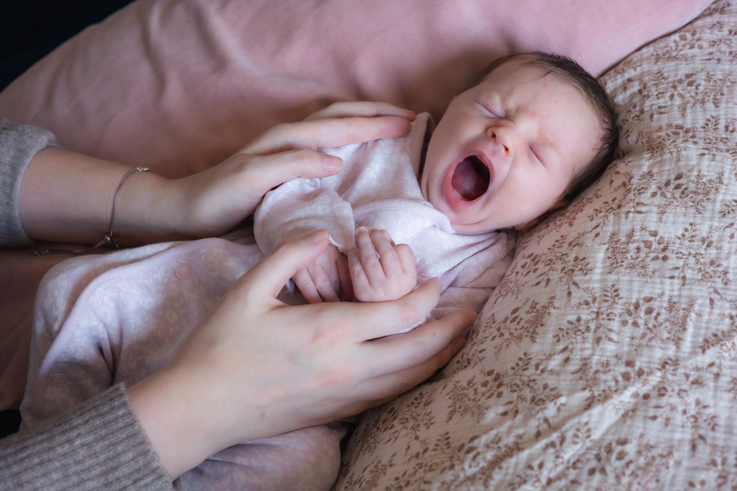 Mum and dad cradling newborn yawning baby girl. Cotswolds, Broadway