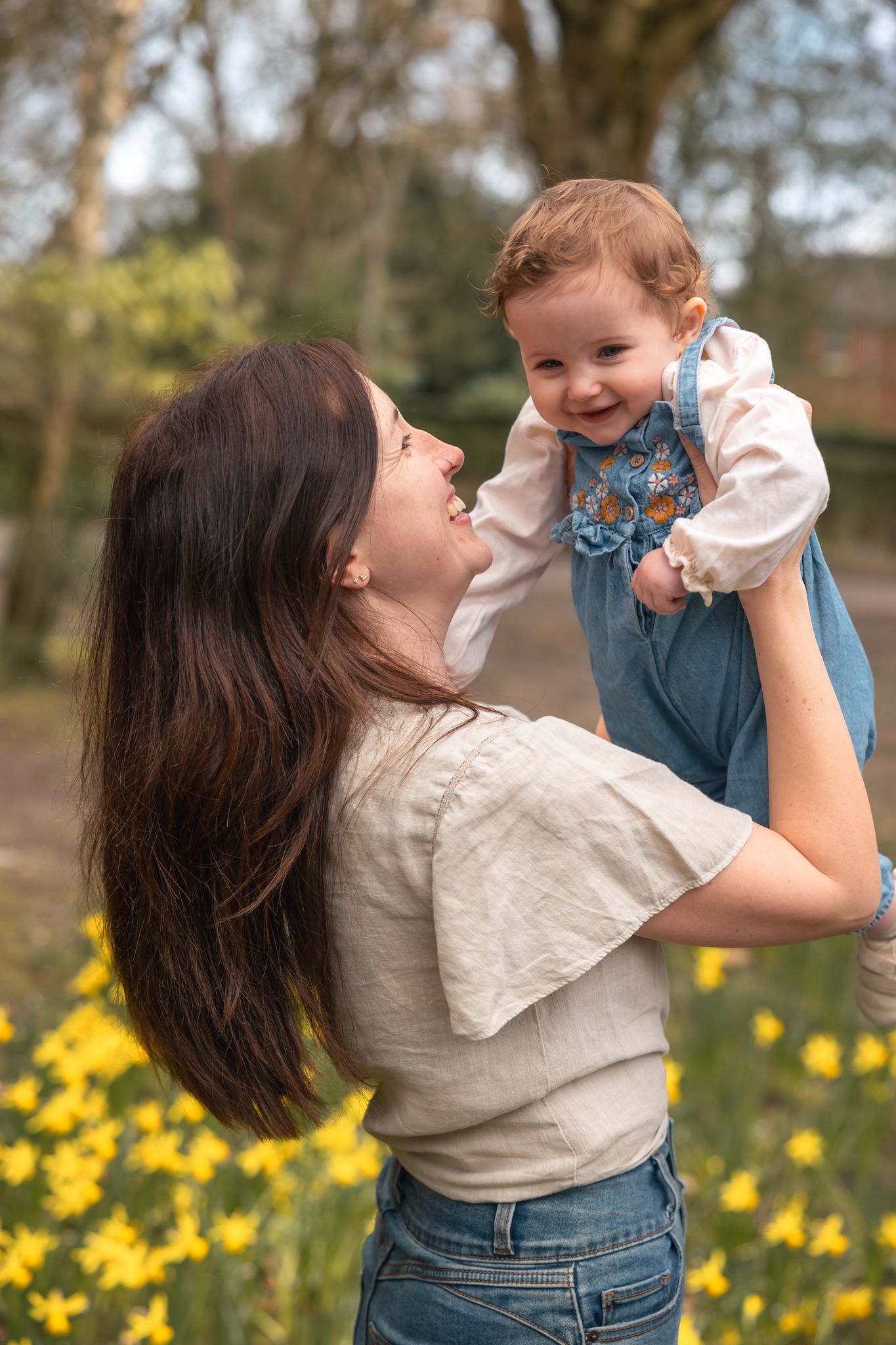 A mum lifting her baby daughter up in the air making her smile. Faringdon, Oxfordshire.