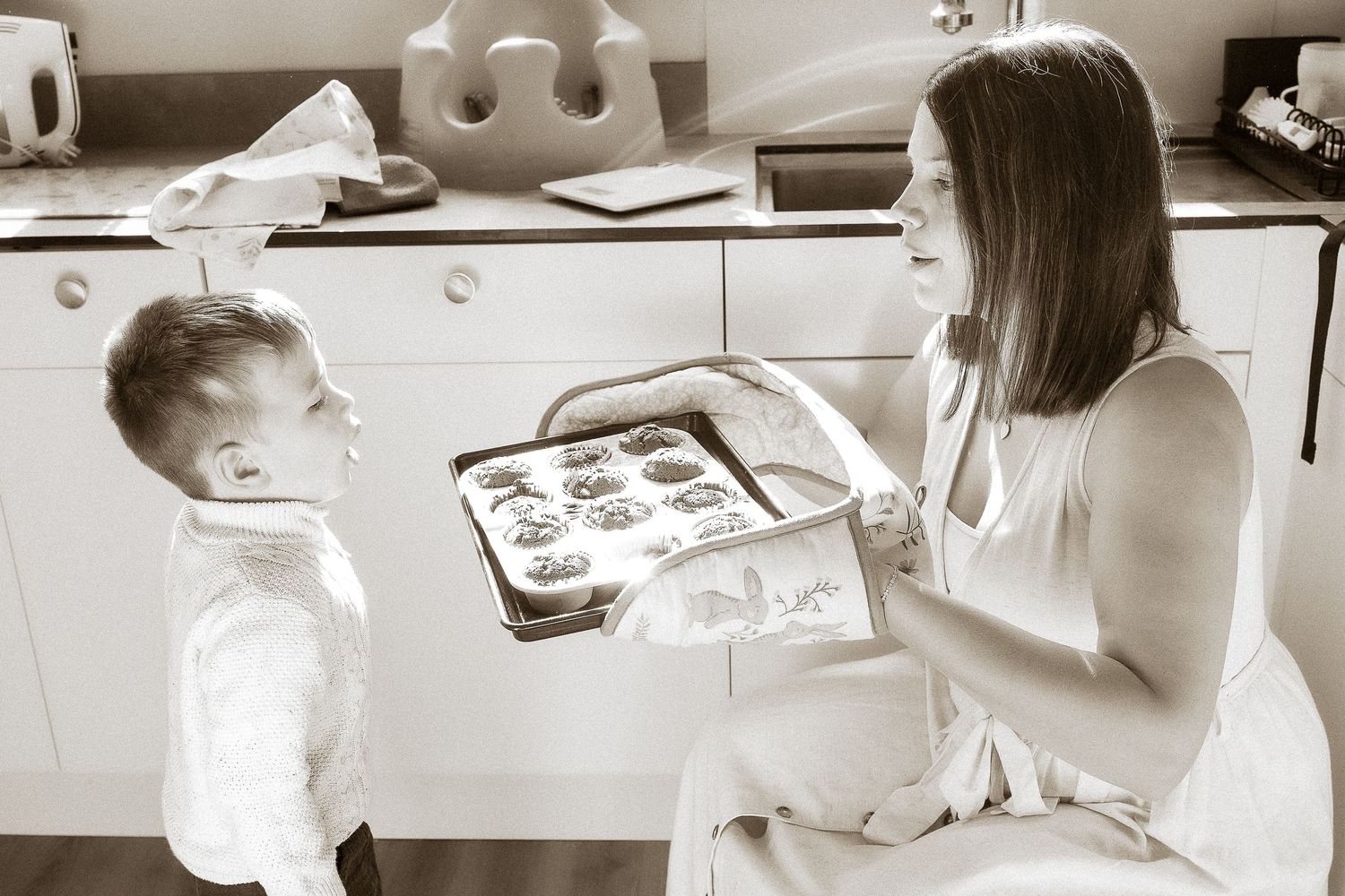 Storytelling Photoshoot of son admiring cakes with mum in Lower Slaughter, Cotswolds.