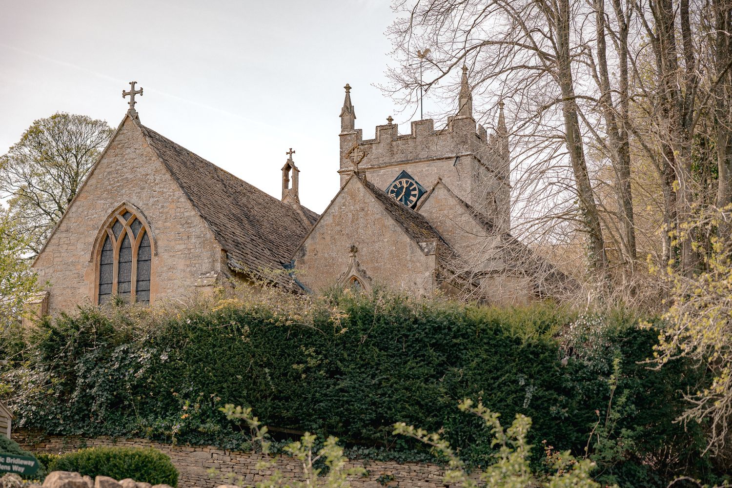 Historic English stone church with Gothic arched windows in Upper Slaughter, Cotswolds, UK.
