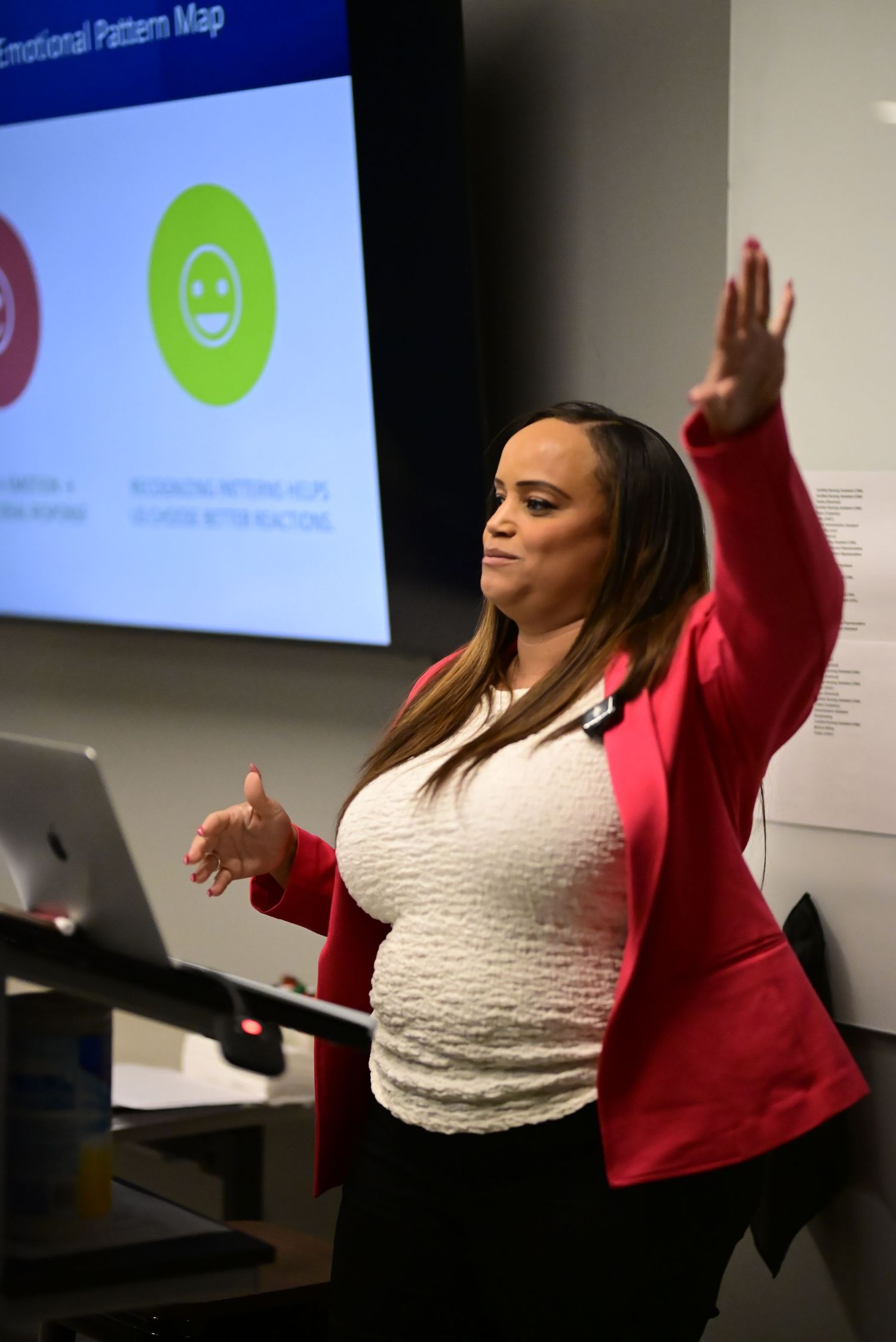 A woman in a red blazer gestures while presenting an Emotional Pattern Map slide.