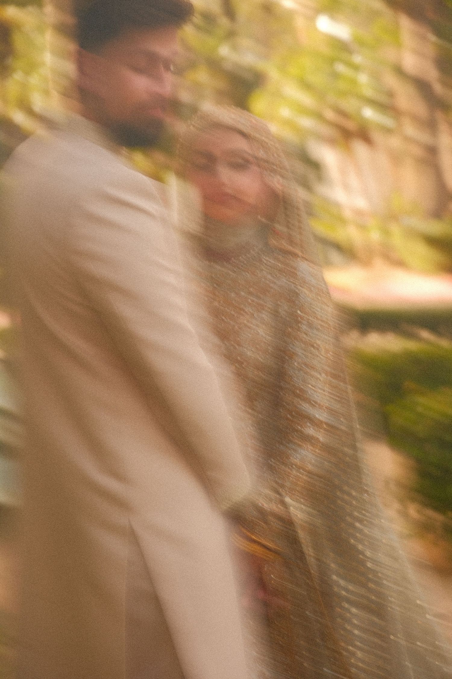 South Asian wedding couple walking together, bride in embroidered dupatta and groom in cream sherwani.