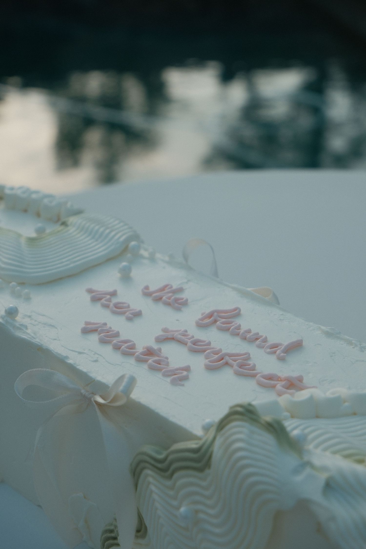 Close-up of a white wedding cake reading 