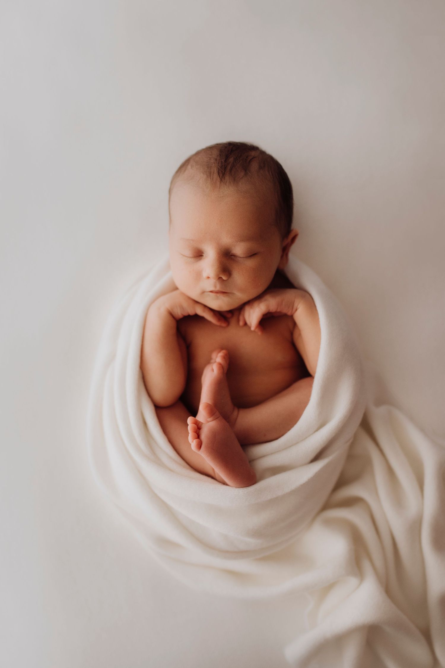 in-home newborn photography Sydney of baby resting beside family dog on bed