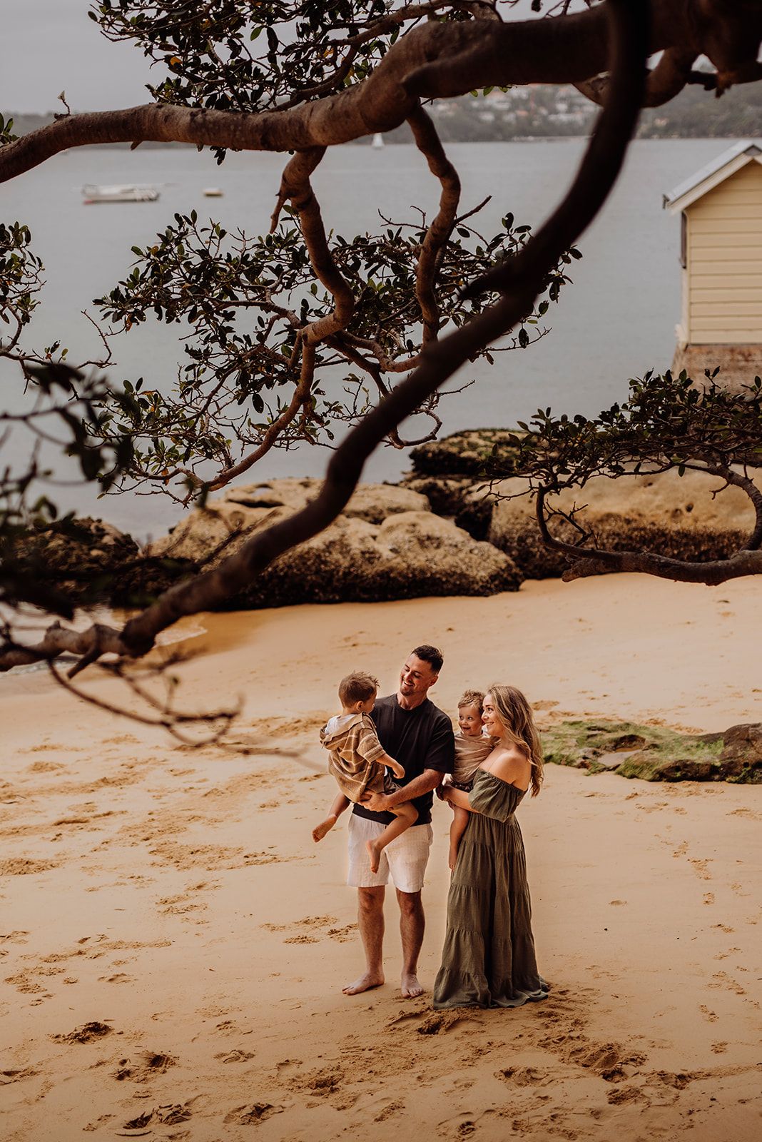 Watsons Bay family photography of parents and children standing on jetty overlooking the water, celebrating their IVF journey