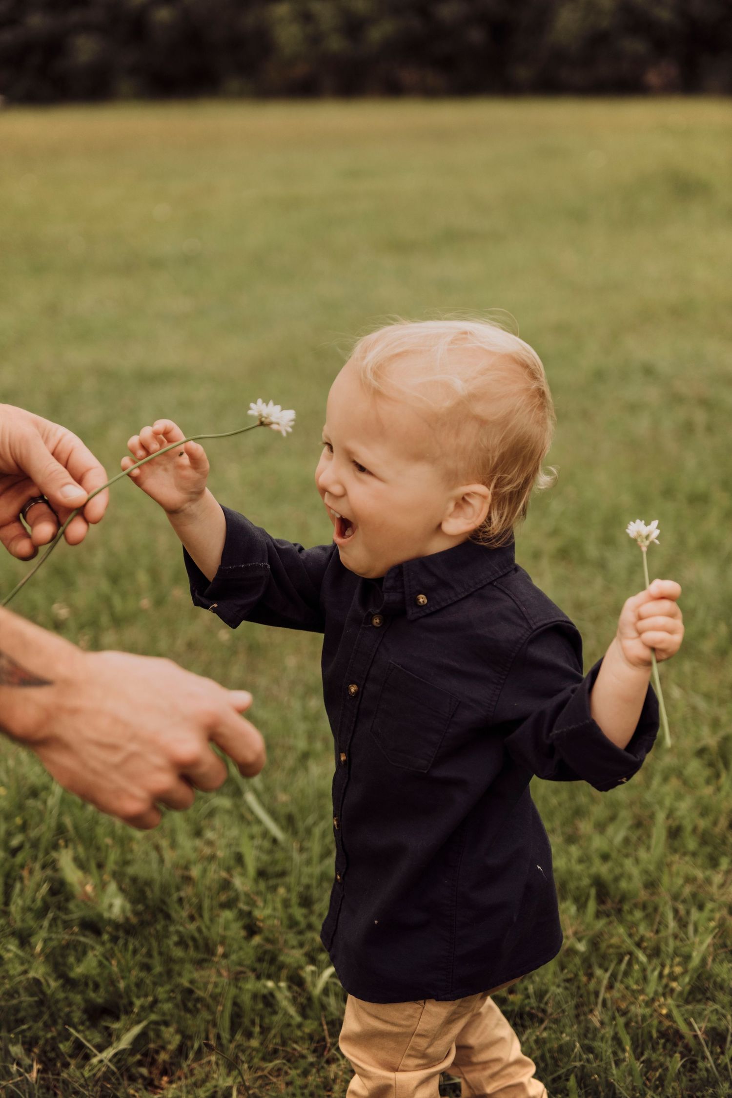 Camden family photography of toddler playing with parent in grassy field