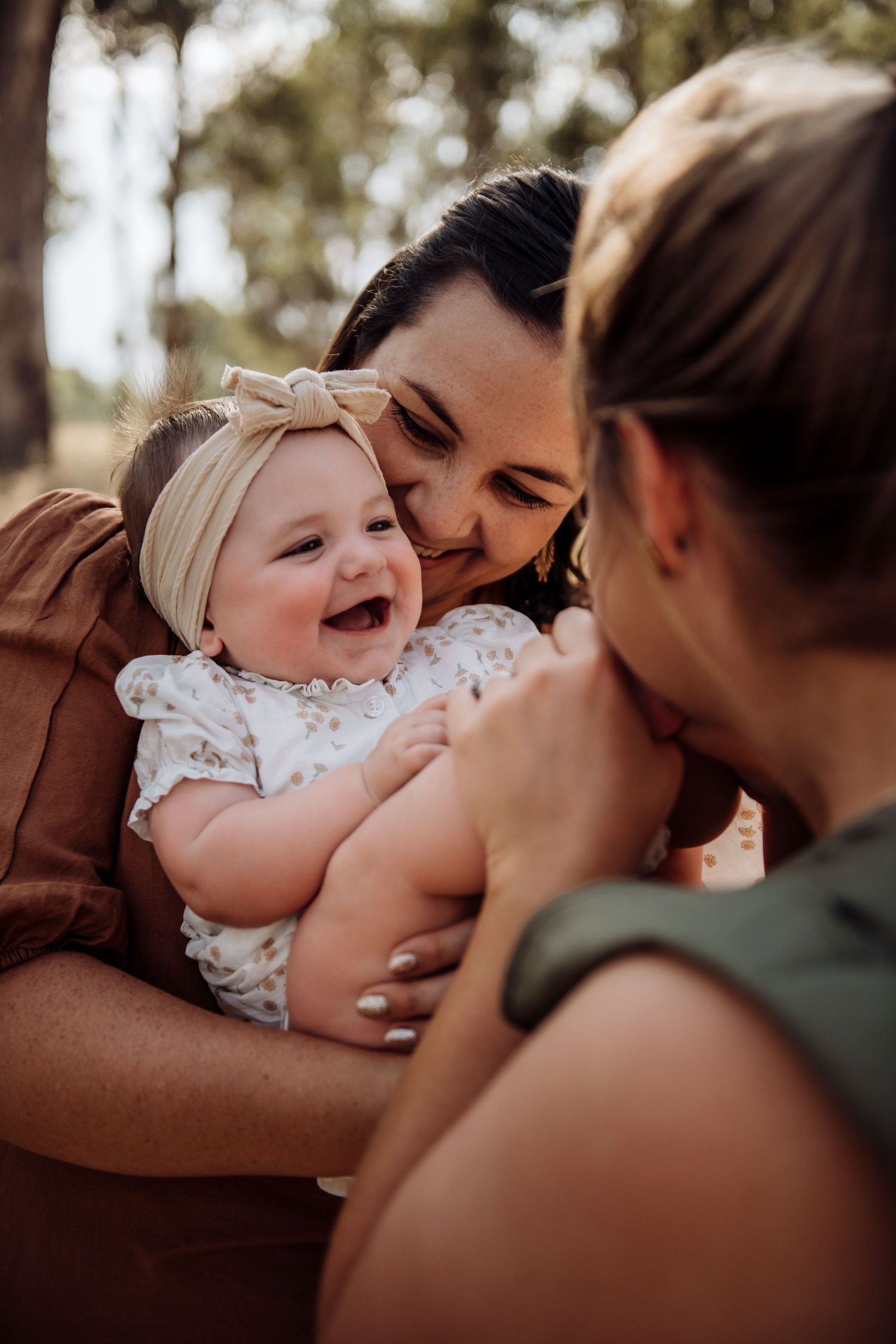 Western Sydney family photography of baby being held and cuddled in natural light lgbtq+ family, IVF success story