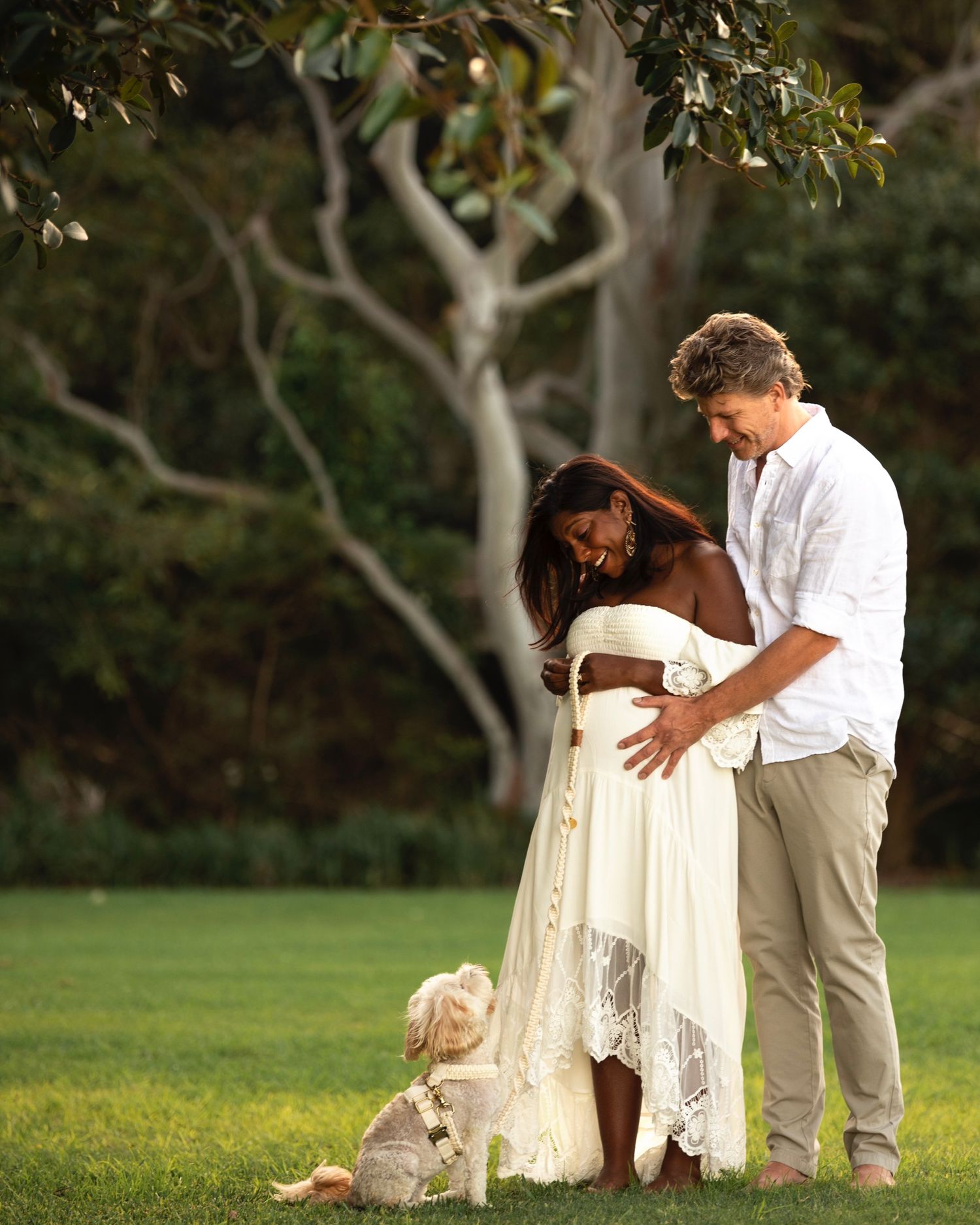 Mosman maternity photography of couple embracing in park with dog in natural light.  ivf success story Rainbow baby