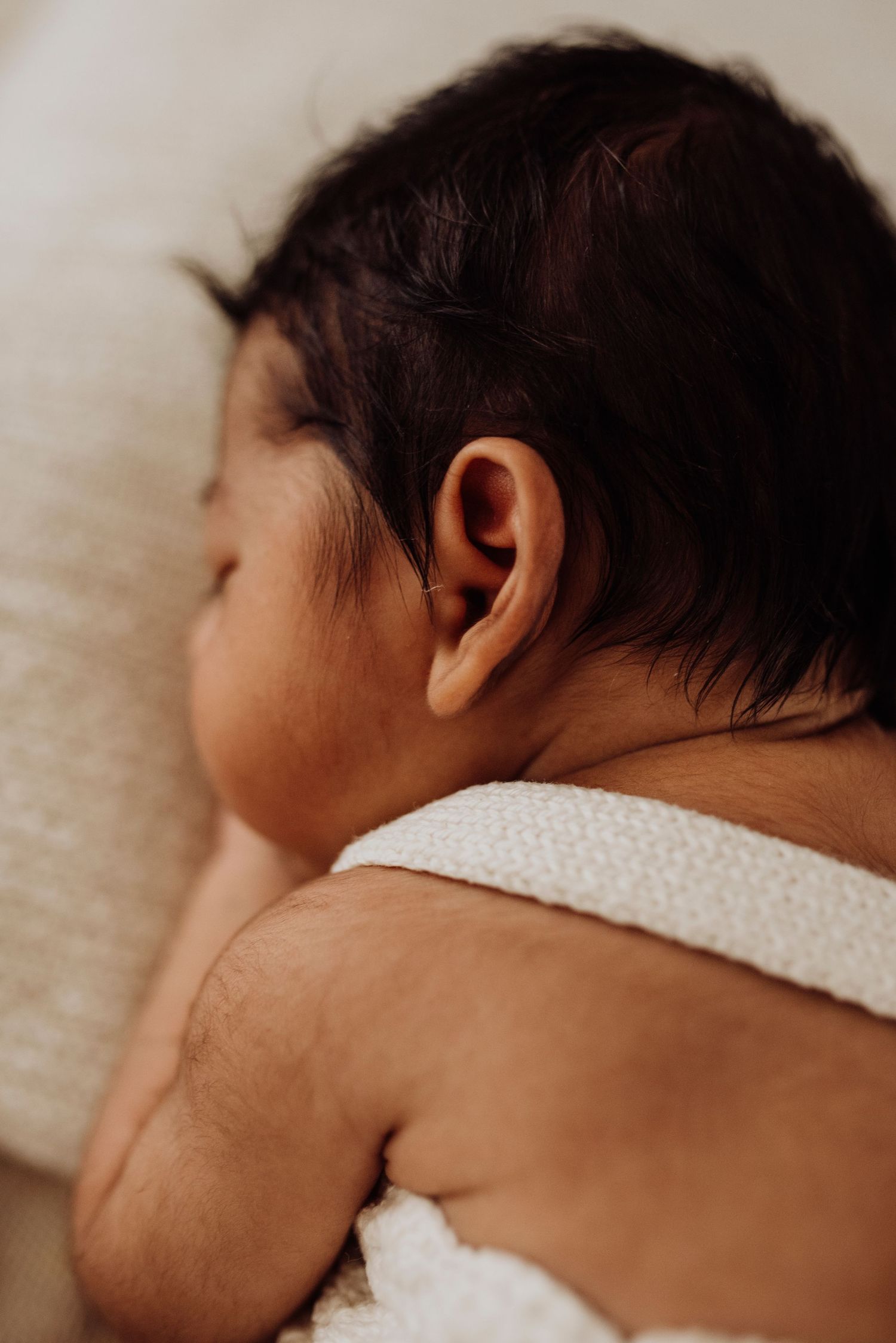 close up of newborn baby ear during in-home newborn photoshoot in Sydney. Rainbow baby.