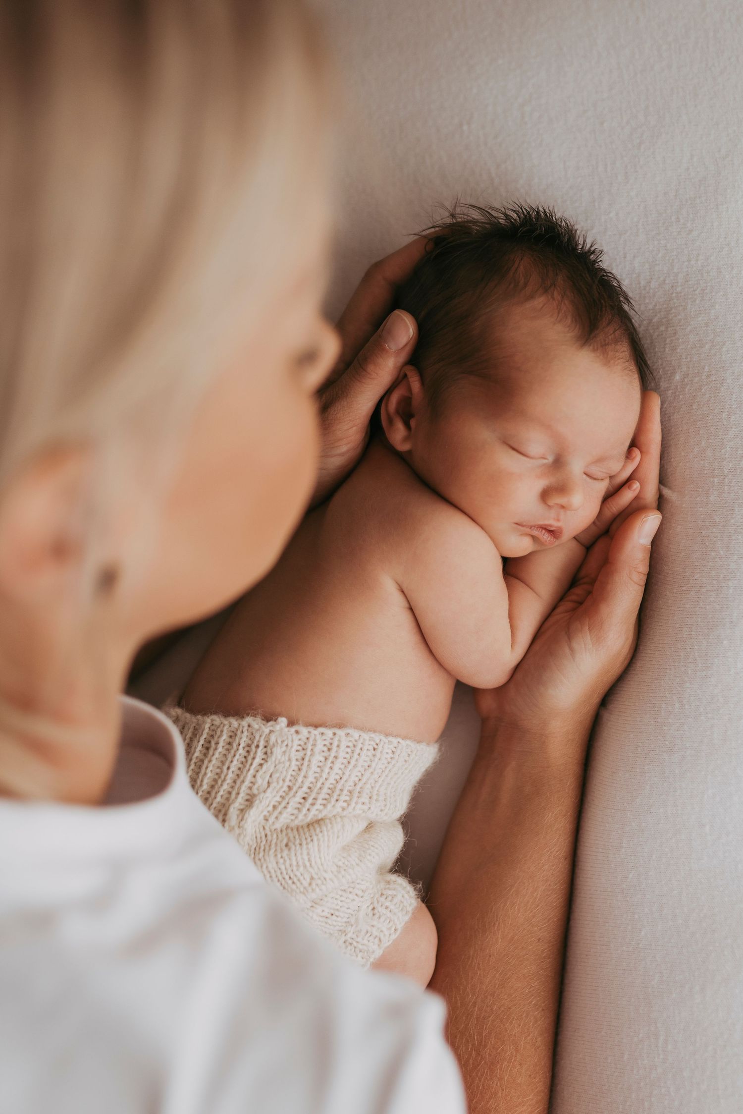 in-home newborn photography Sydney of mother gently holding sleeping newborn baby, intimate moment