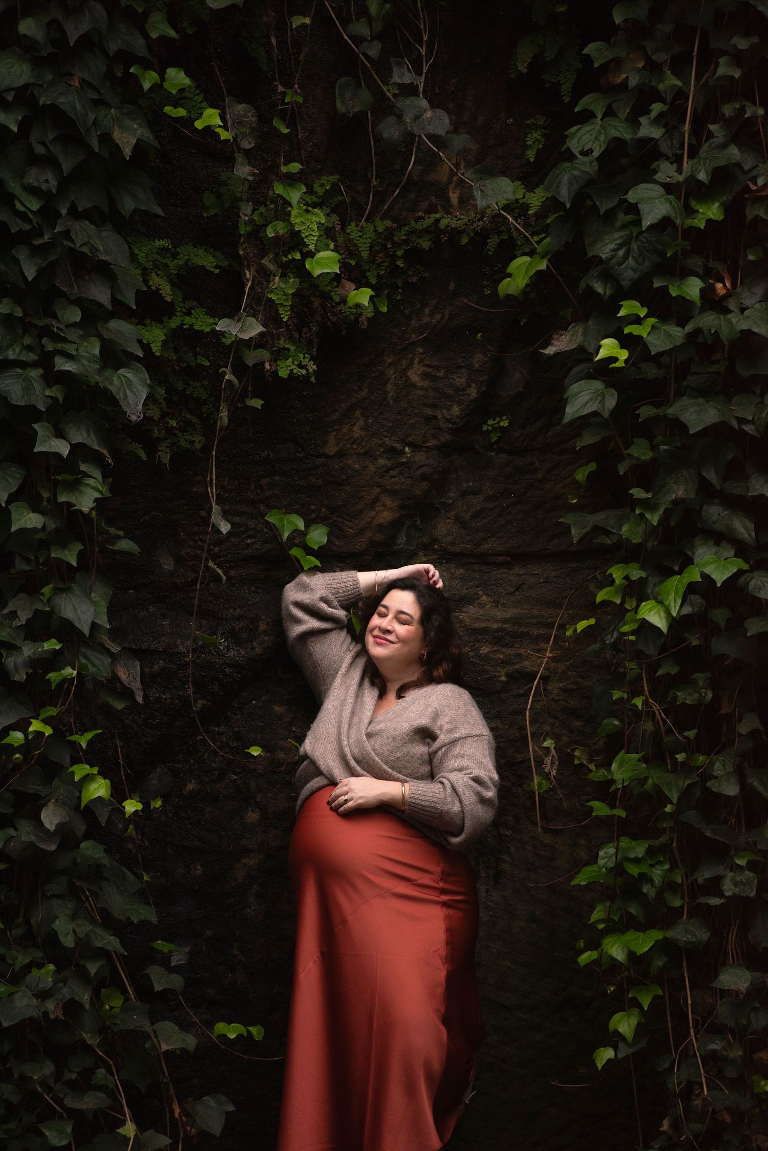 Maternity photography Sydney featuring pregnant woman in natural setting with greenery and soft moody light. IVF success story. rainbow baby