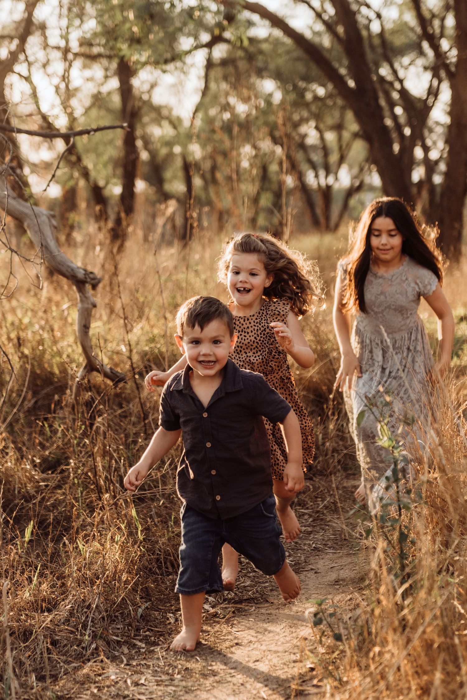 Hawkesbury family photography of children running through bushland in golden light