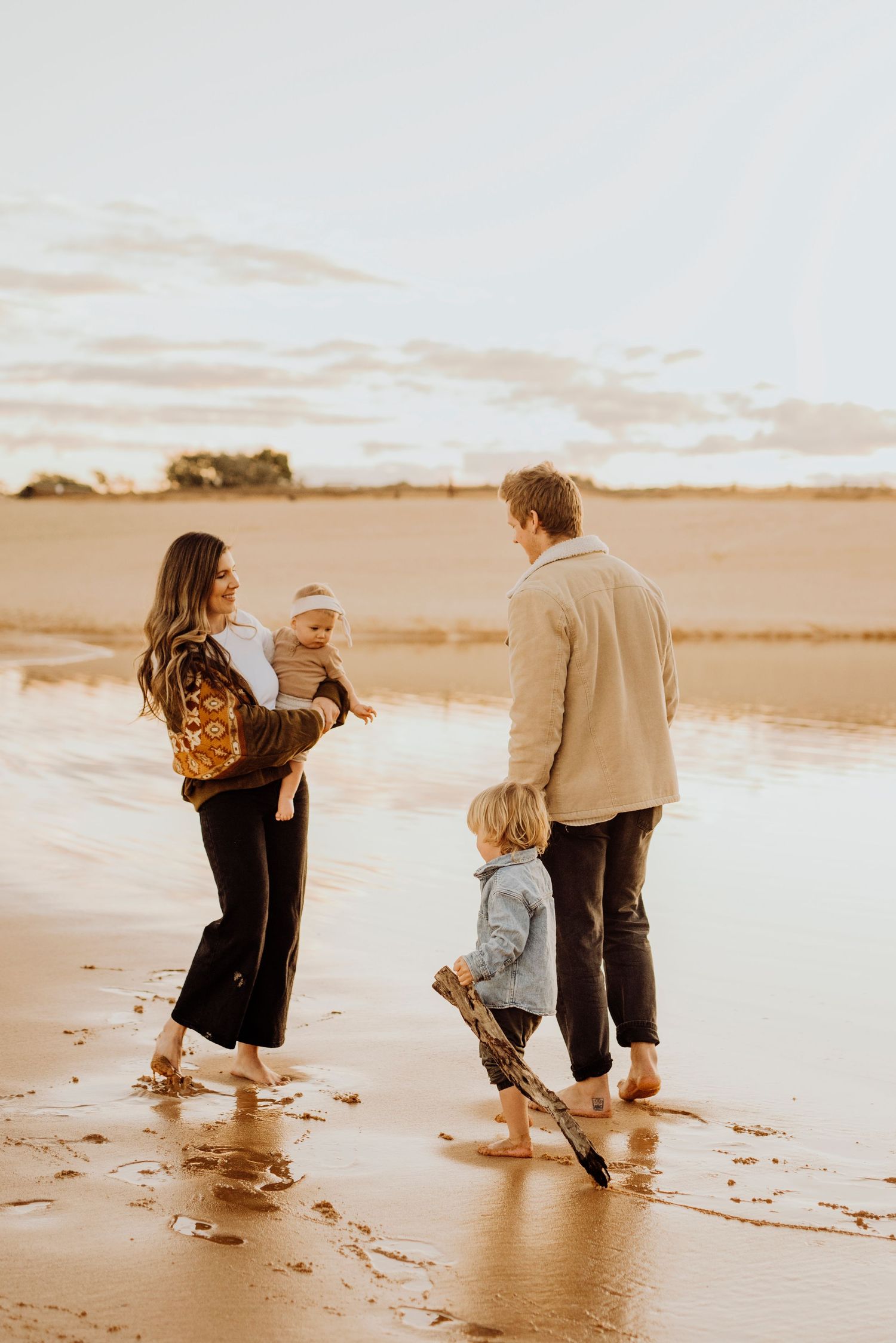 Northern Beaches family photography of family walking together along shoreline at sunset