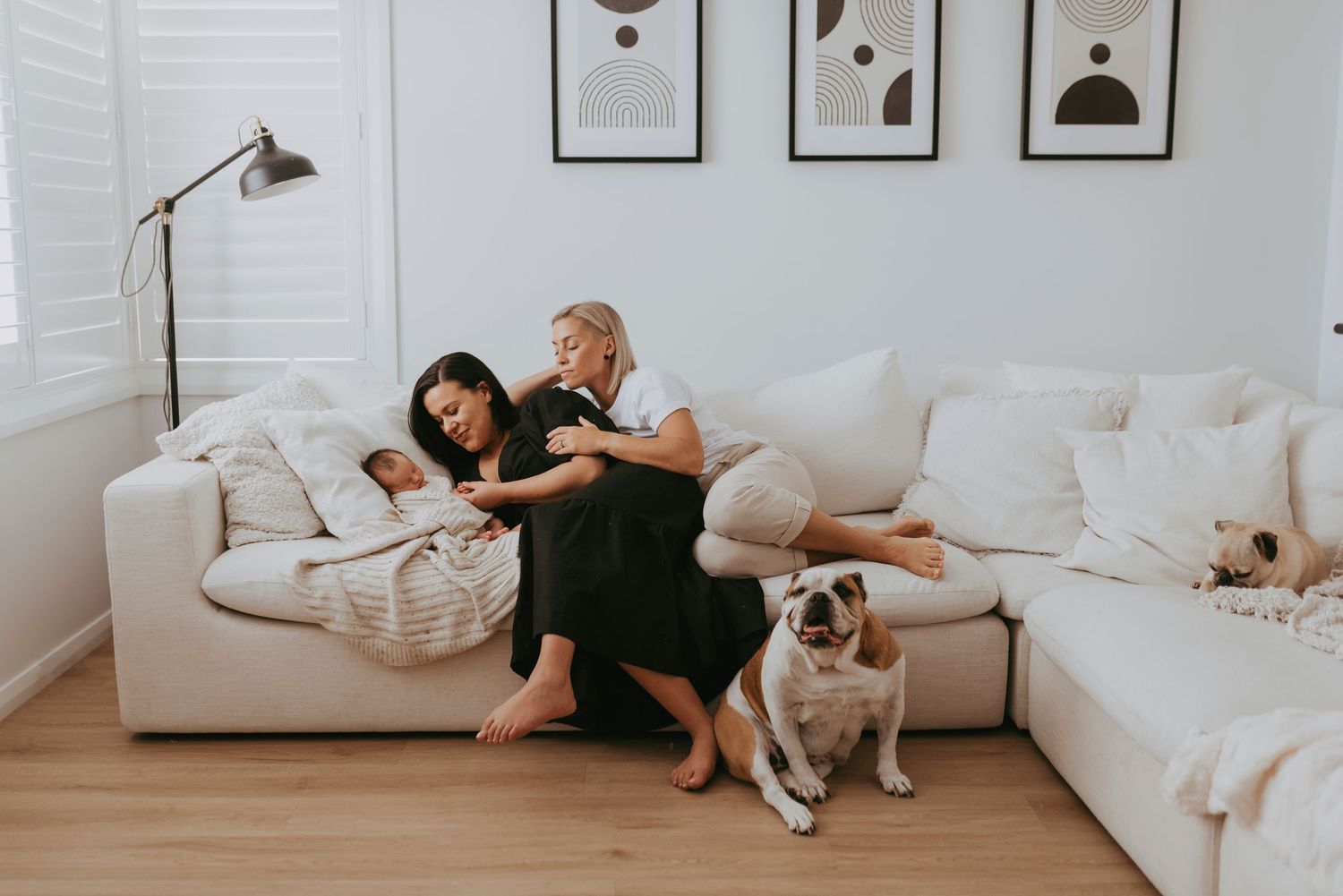 in-home family and newborn photography Sydney of mother and baby on sofa with dogs in bright living room