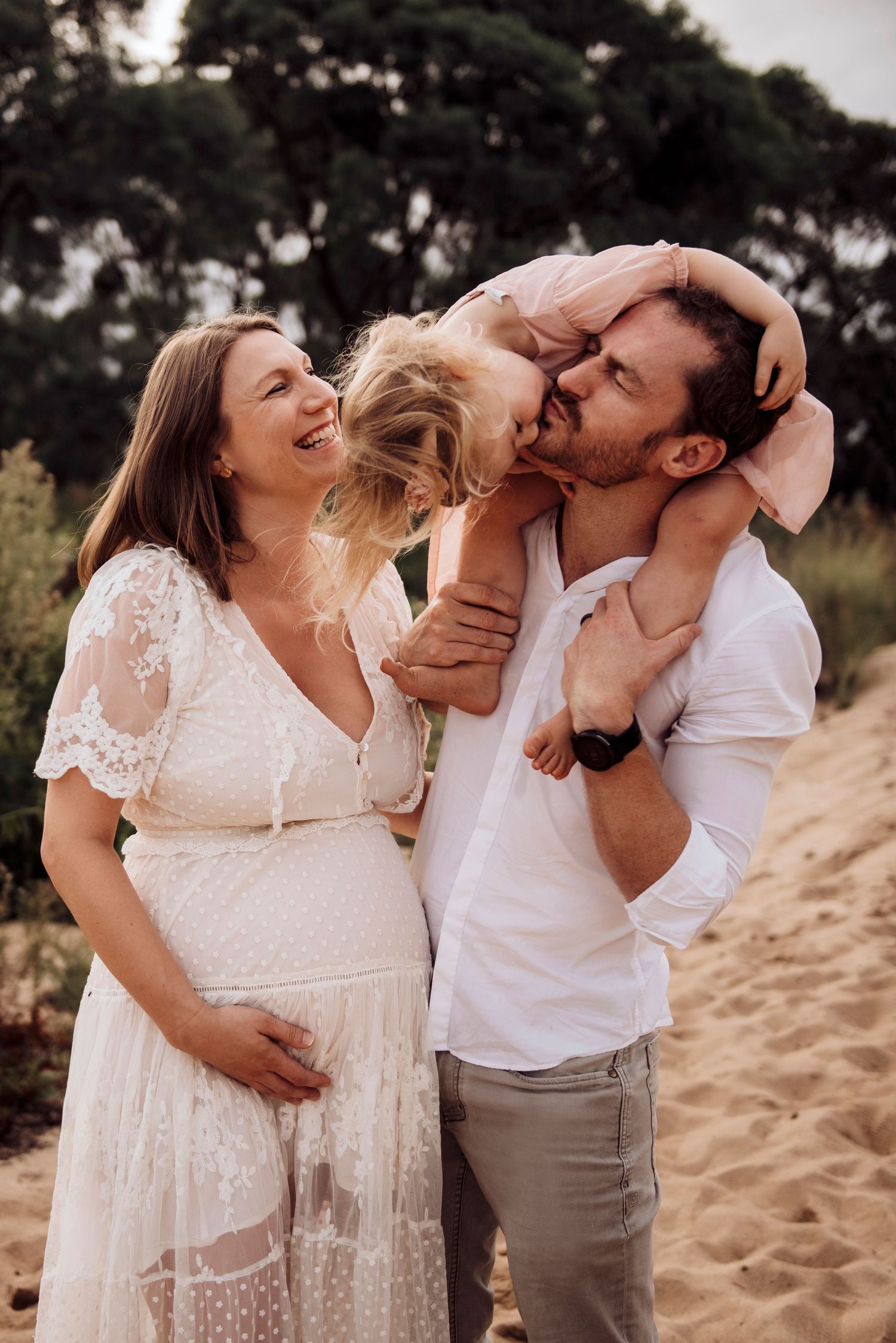 Western Sydney maternity photoshoot with couple and toddler sharing playful moment outdoors. dress from Mamarentals. IVF success story