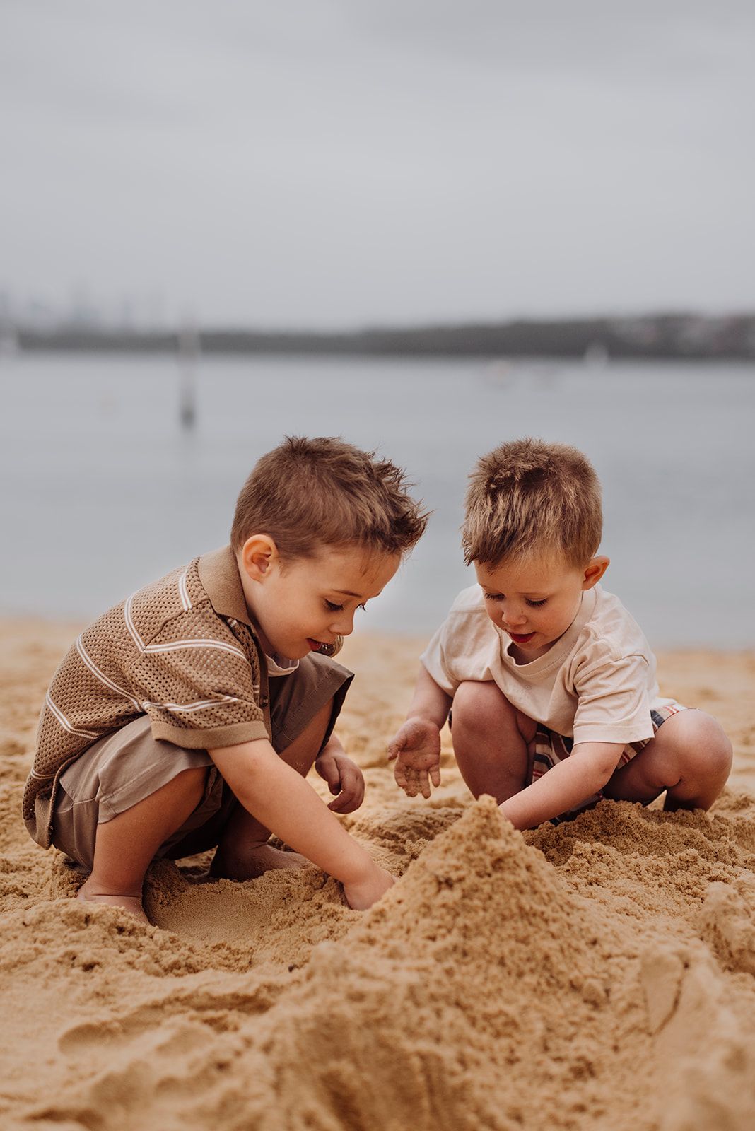 Watsons Bay family photography of two children playing together in the sand