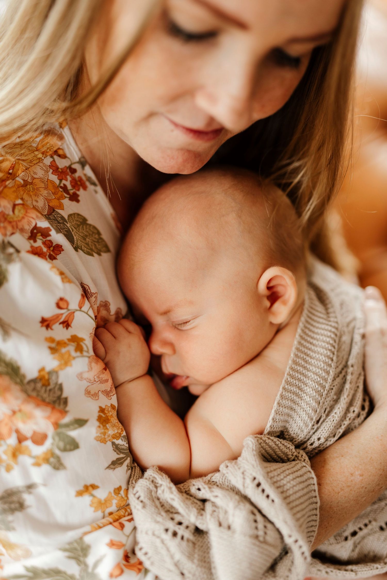 Penrith newborn photography of mother holding baby in soft connected moment